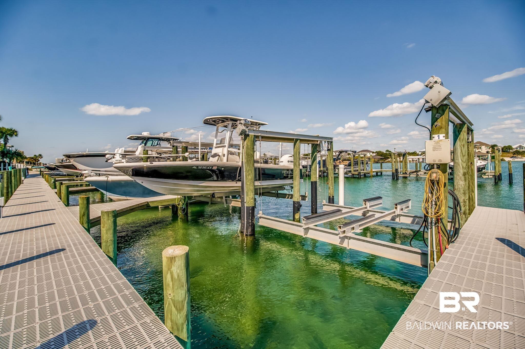 Image 3: Dock featuring boat lift and a water view