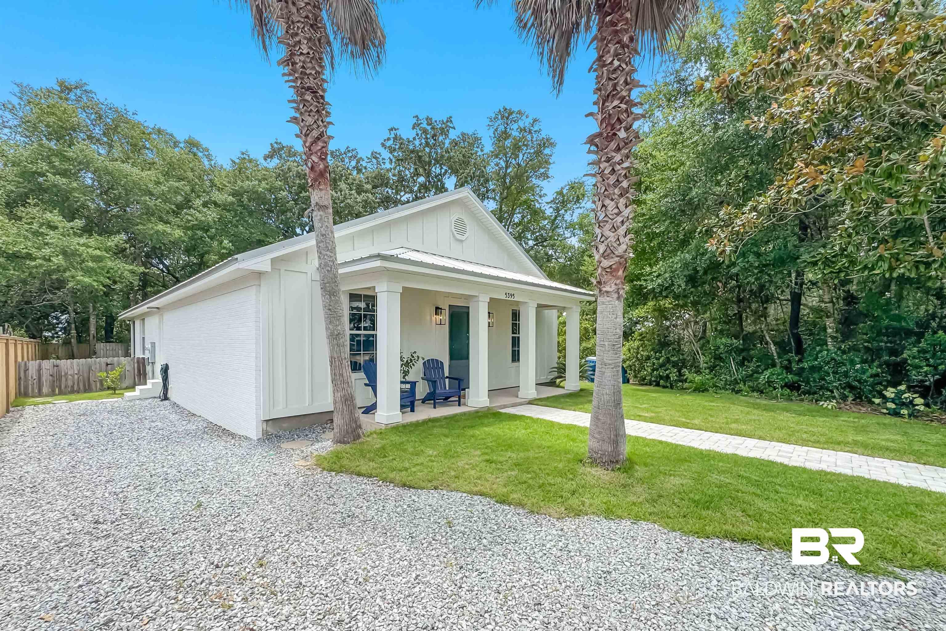 Image 2: White exterior residence with a covered front porch featuring square columns