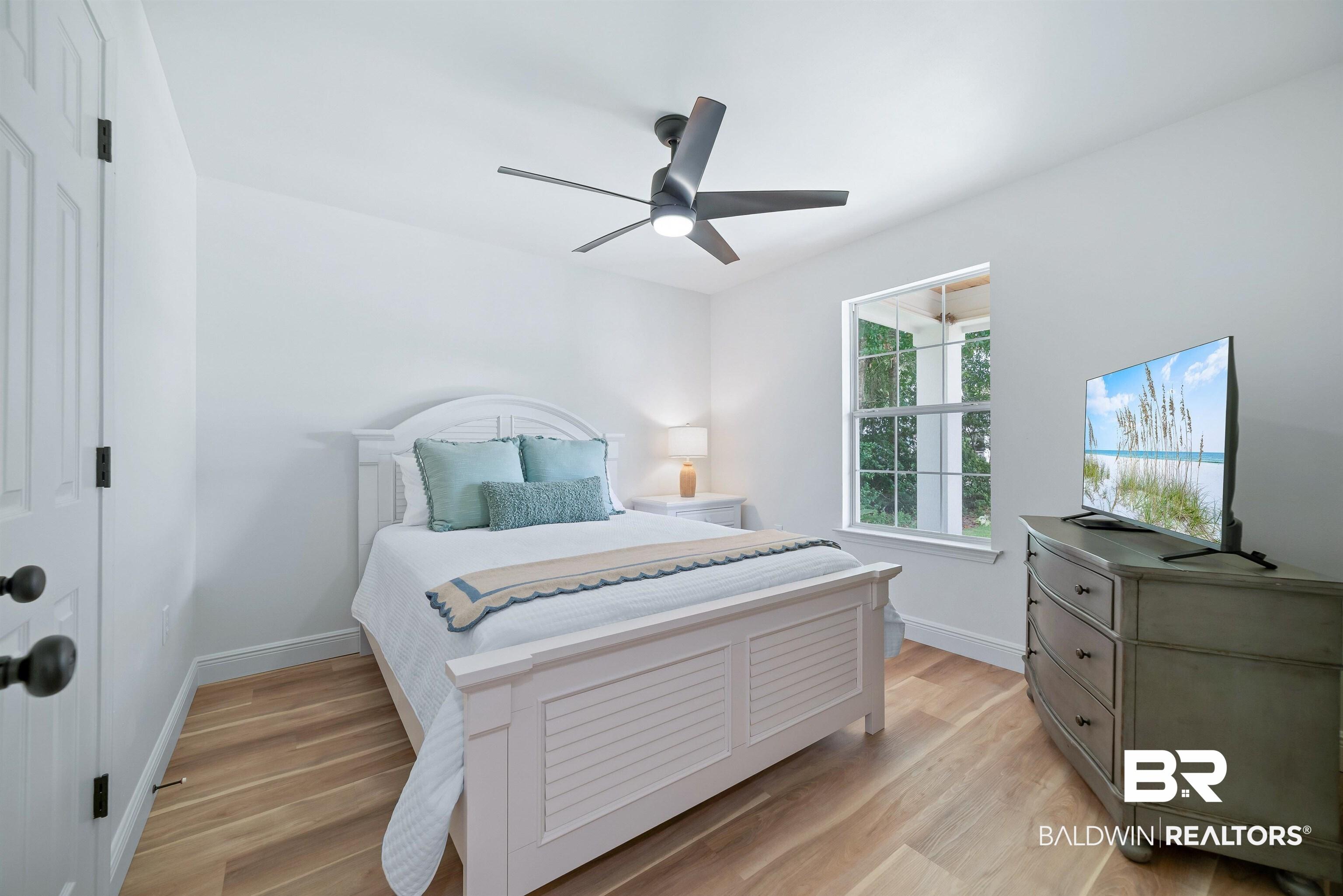 Image 4: Light-filled room featuring wood-finish flooring, a contemporary ceiling fan, and a single window offering exterior views