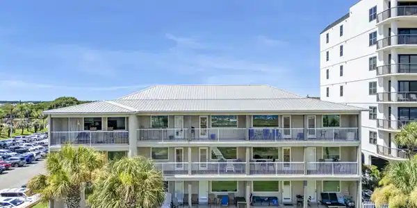 Image 2: Multi-story condominium building featuring a metal roof and multiple private balconies
