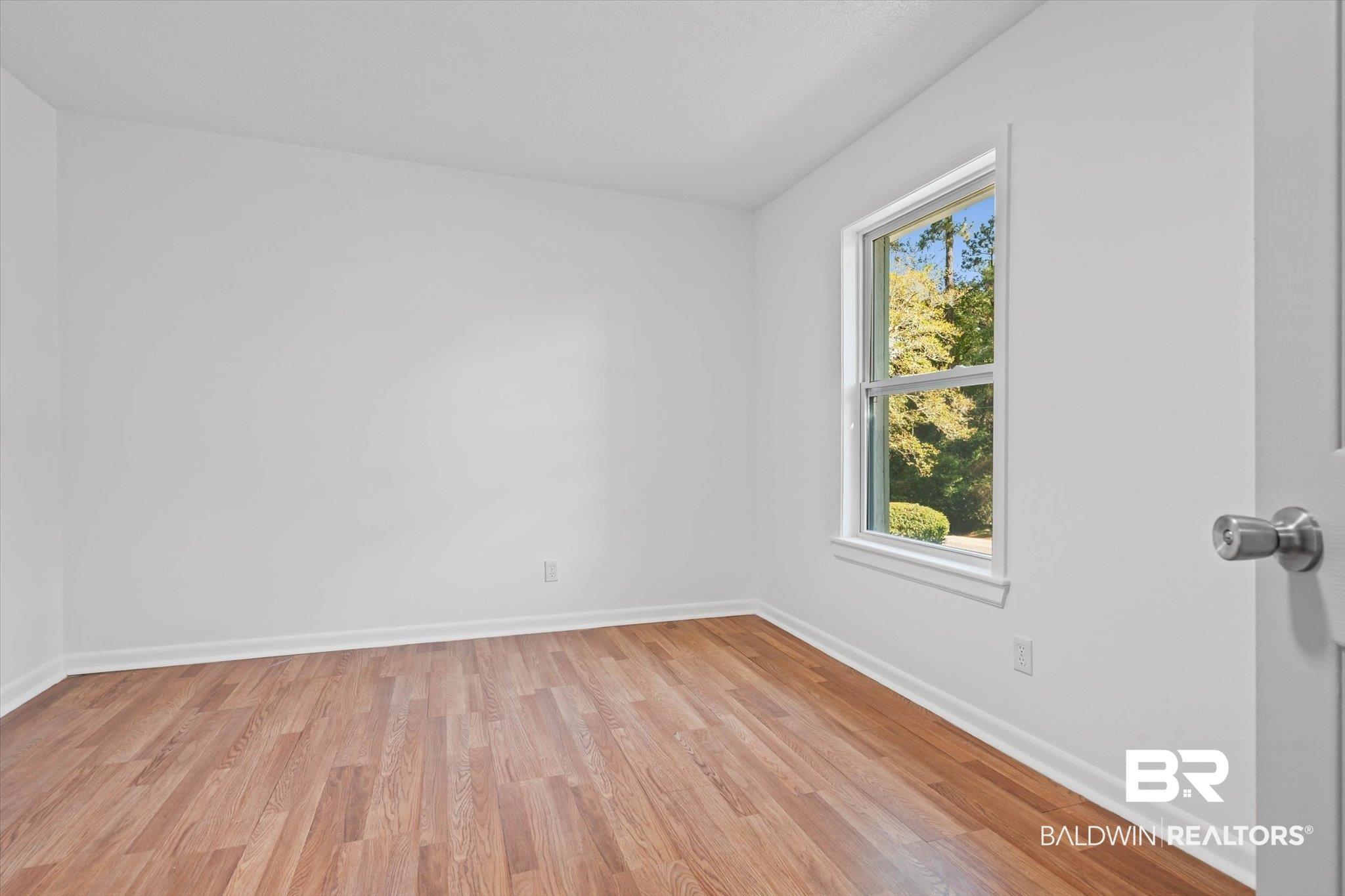 Image 3: Living area with wood flooring.