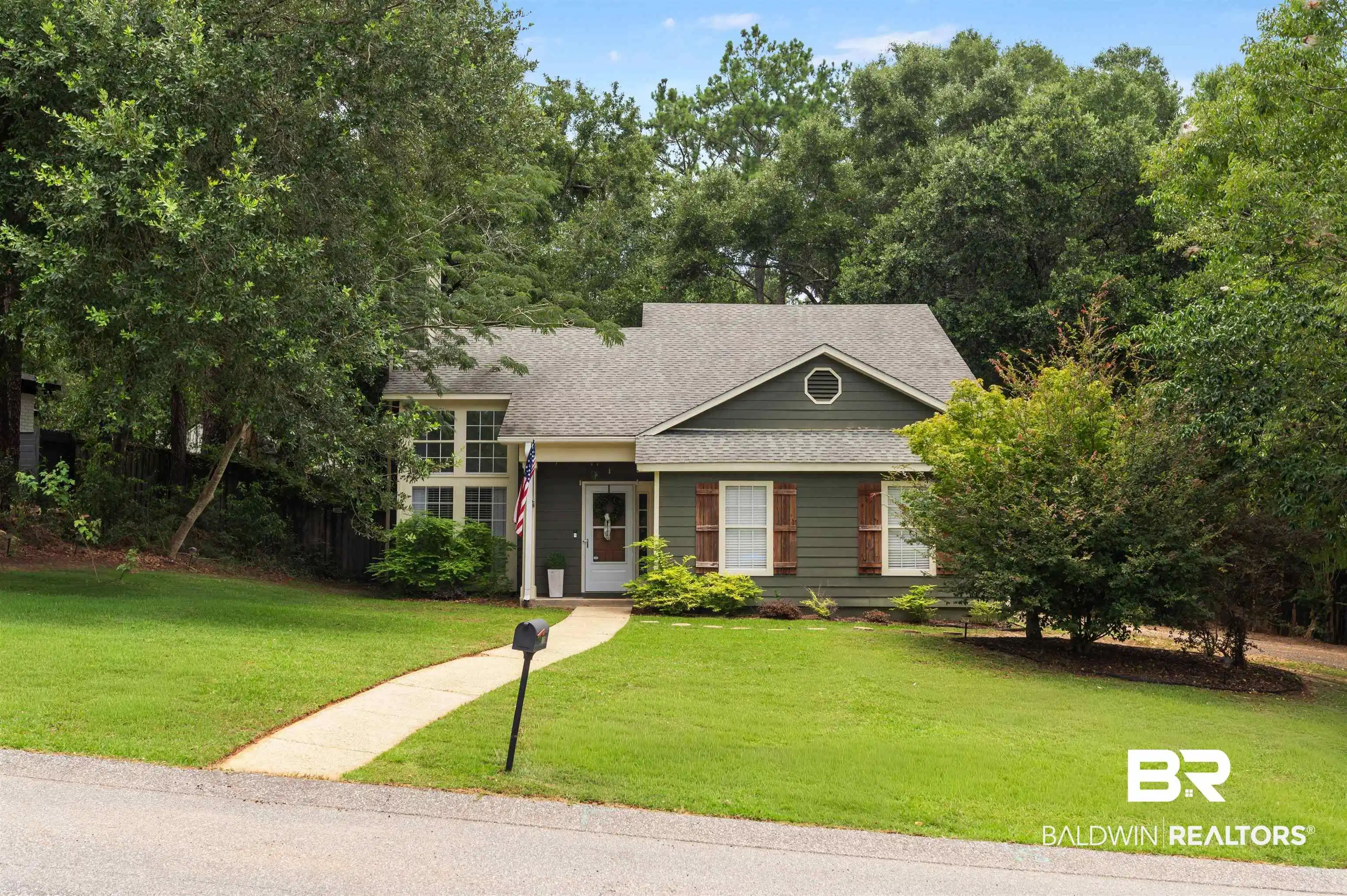 Image 1: Dark green exterior siding with white trim and a gabled roofline