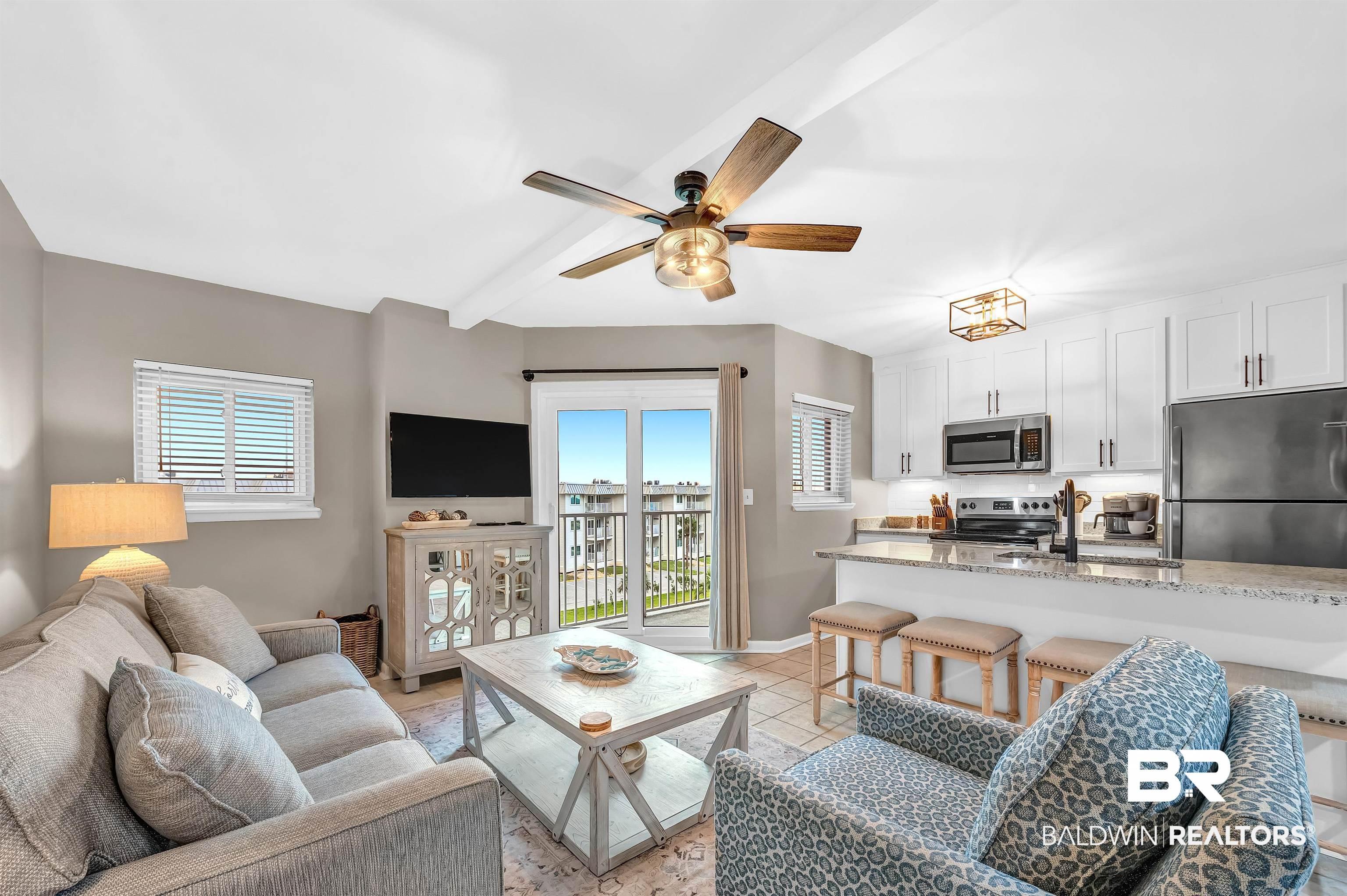Image 4: Open-concept living area with tile flooring and a ceiling fan