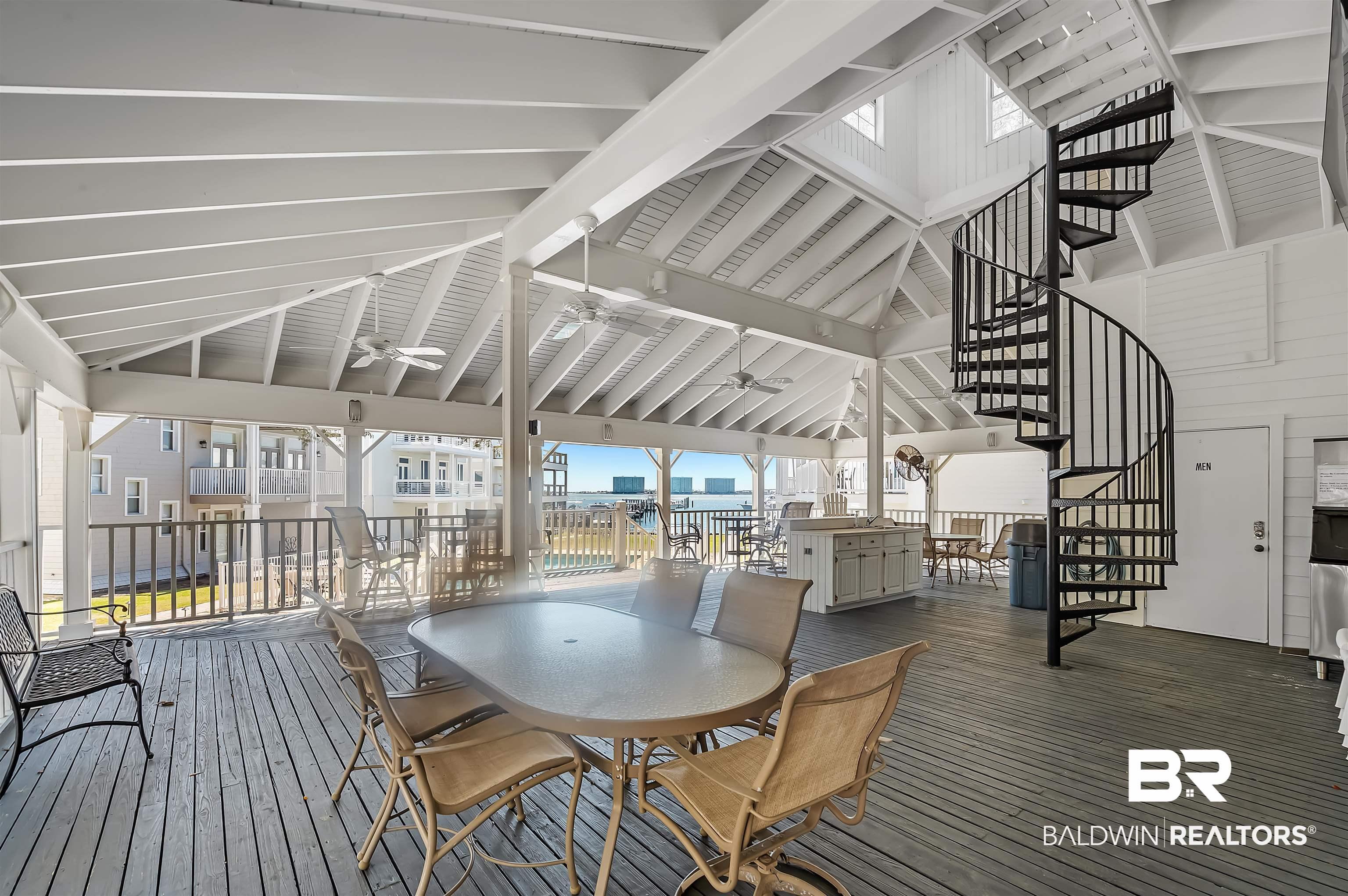 Image 4: Wooden terrace featuring stairway, outdoor dining area, and a ceiling fan