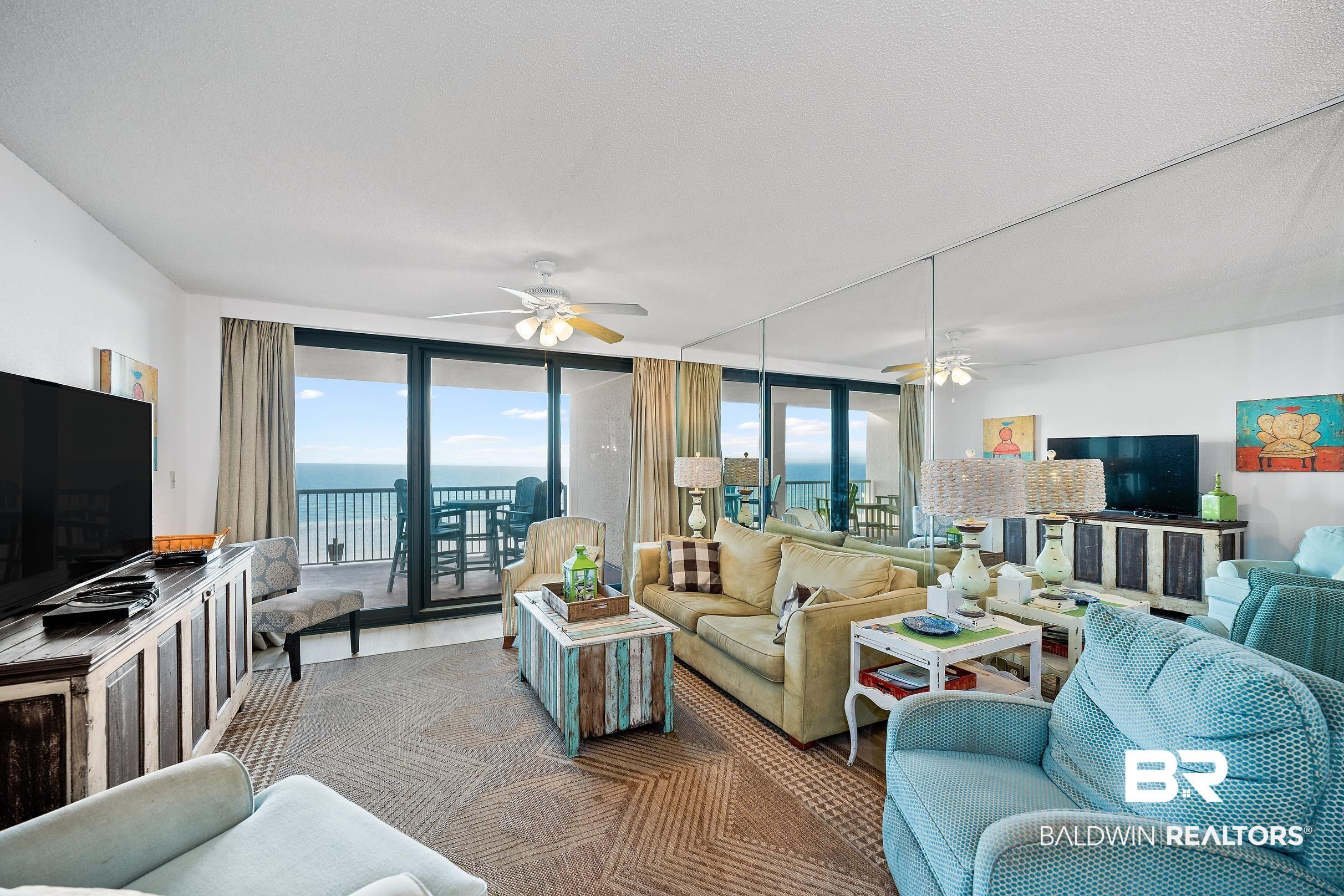 Image 1: Living room featuring a ceiling fan and a wall of windows