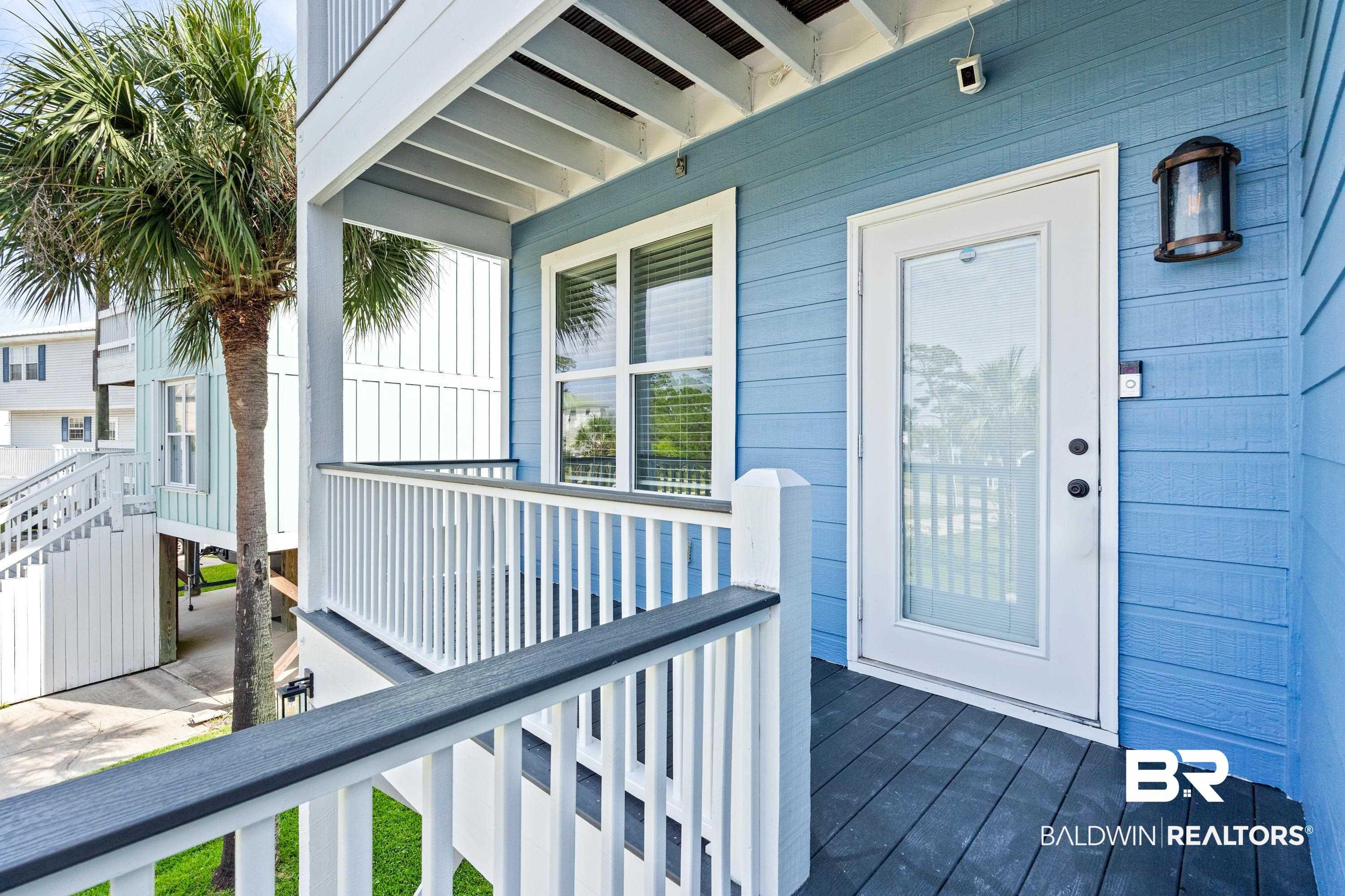 Image 2: Exterior porch featuring horizontal plank siding in a light blue finish