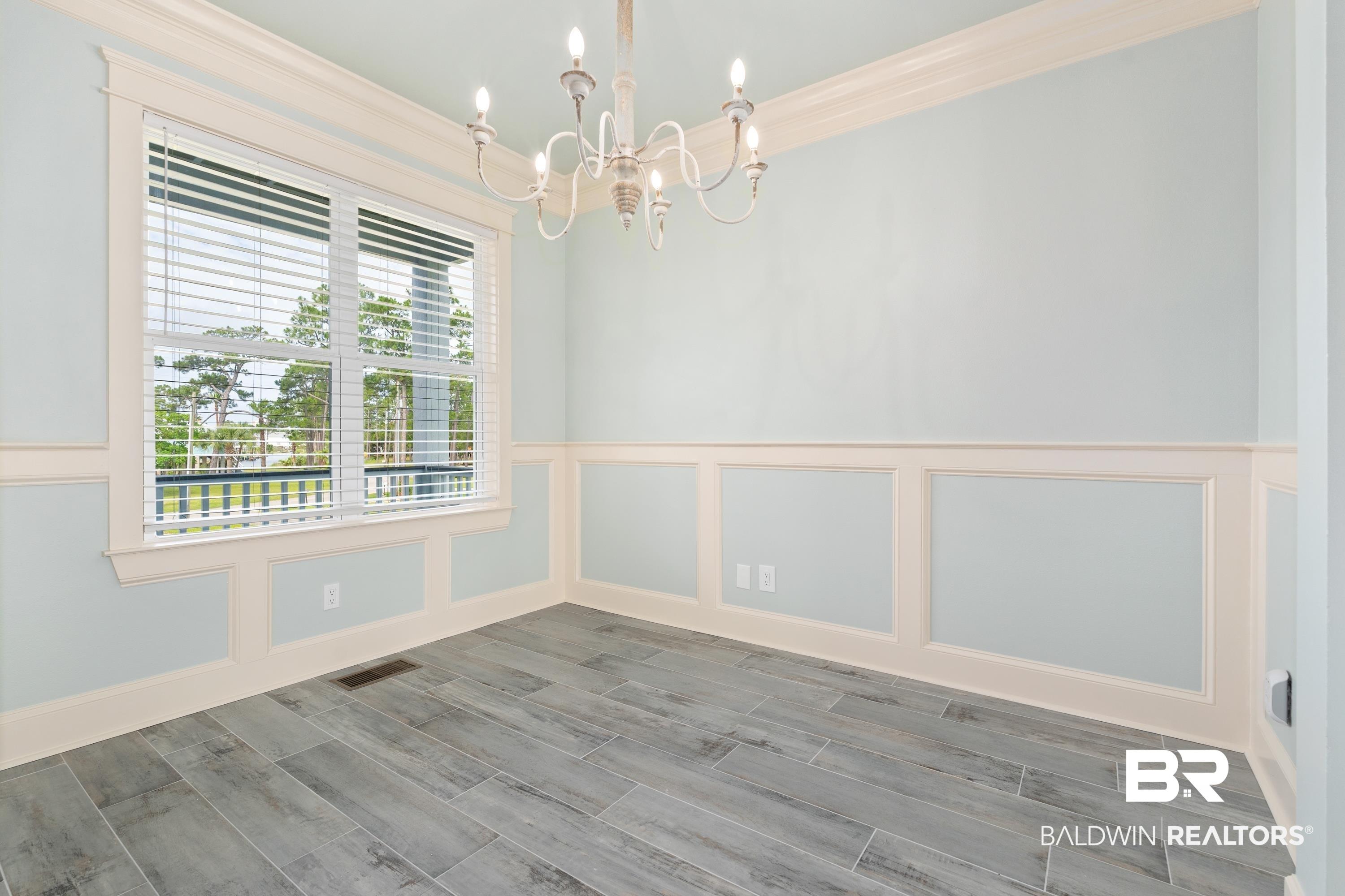 Image 3: Interior space featuring wood-finish tile flooring, wainscoting, and crown molding