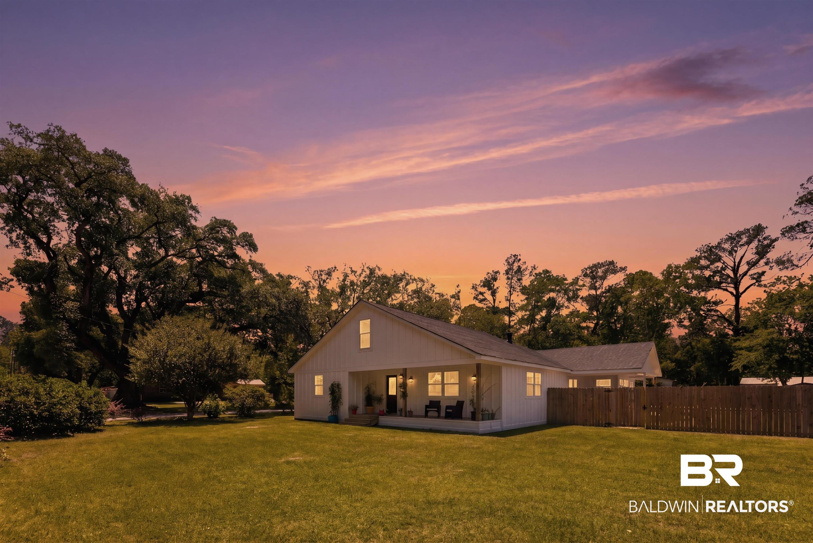 Image 2: White modern farmhouse style residence featuring a covered front porch, a gabled roofline, and board-and-batten siding