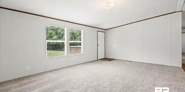 Image 4: Spacious interior room with light gray wall panels and contrasting dark wood trim