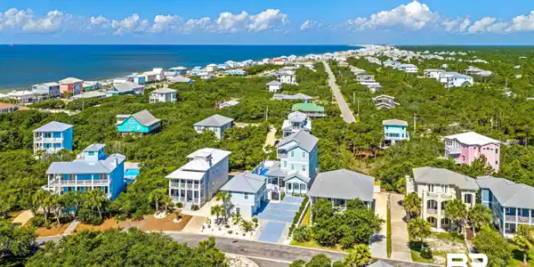 Image 3: Coastal community featuring a dense tree canopy and numerous homes with varying architectural styles
