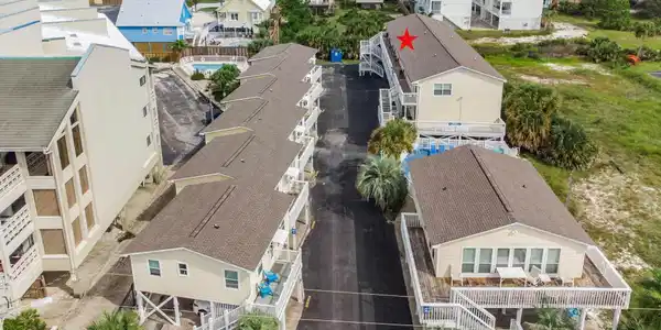 Image 3: Aerial view of residential area featuring a nearby body of water