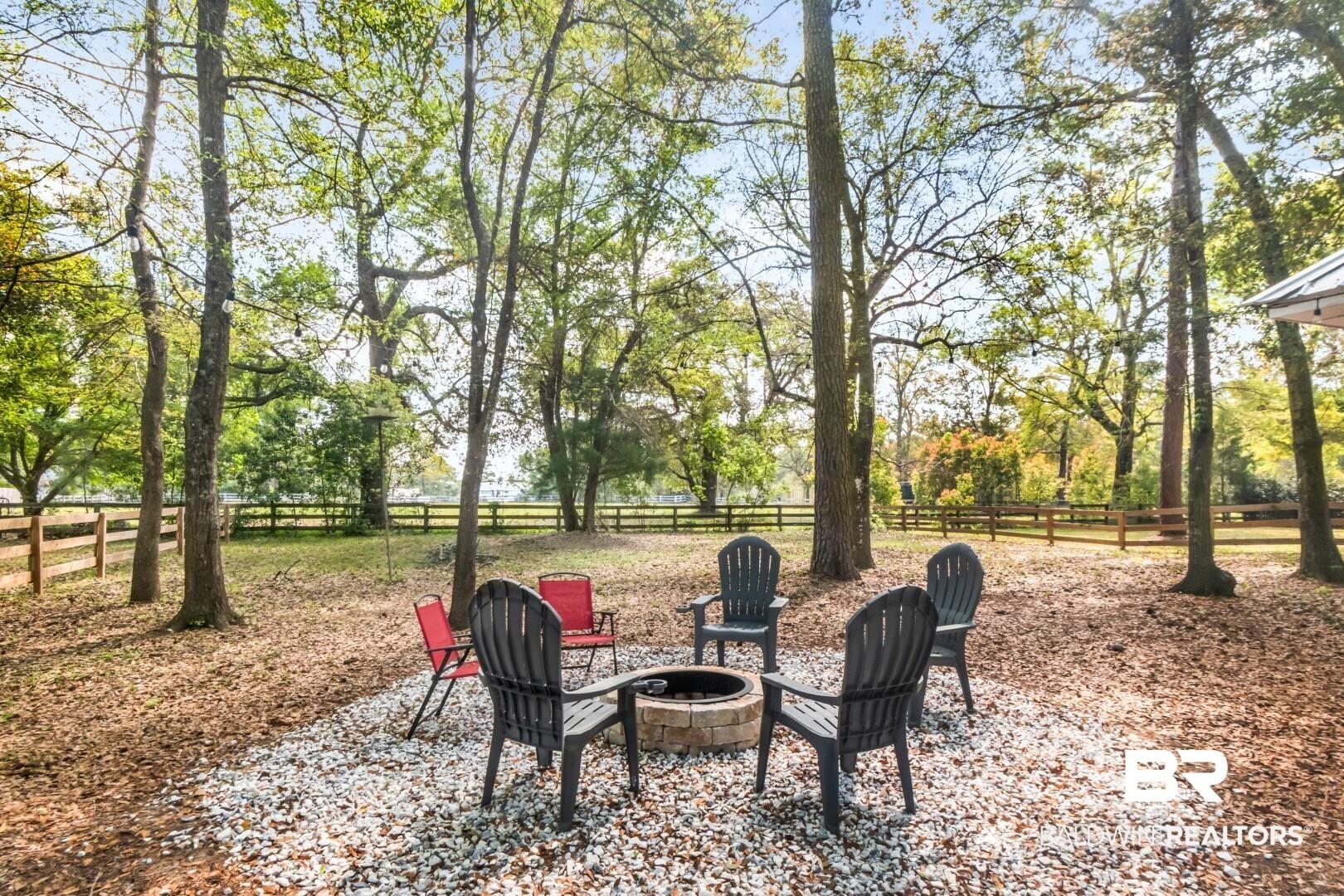 Image 4: Fenced backyard with a patio area and an outdoor fire pit