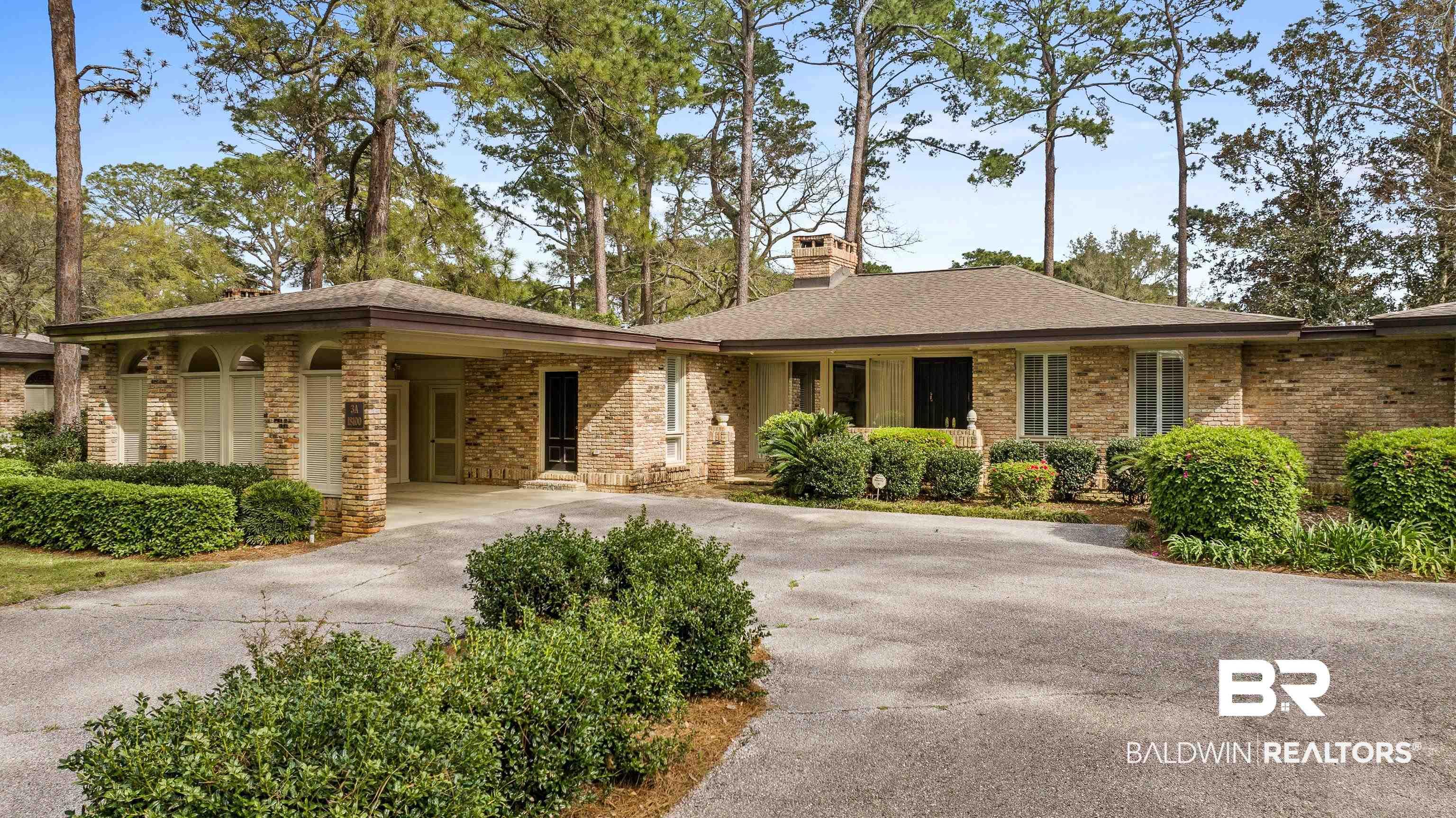 Image 1: Ranch-style house featuring driveway, a chimney, brick siding, and a carport