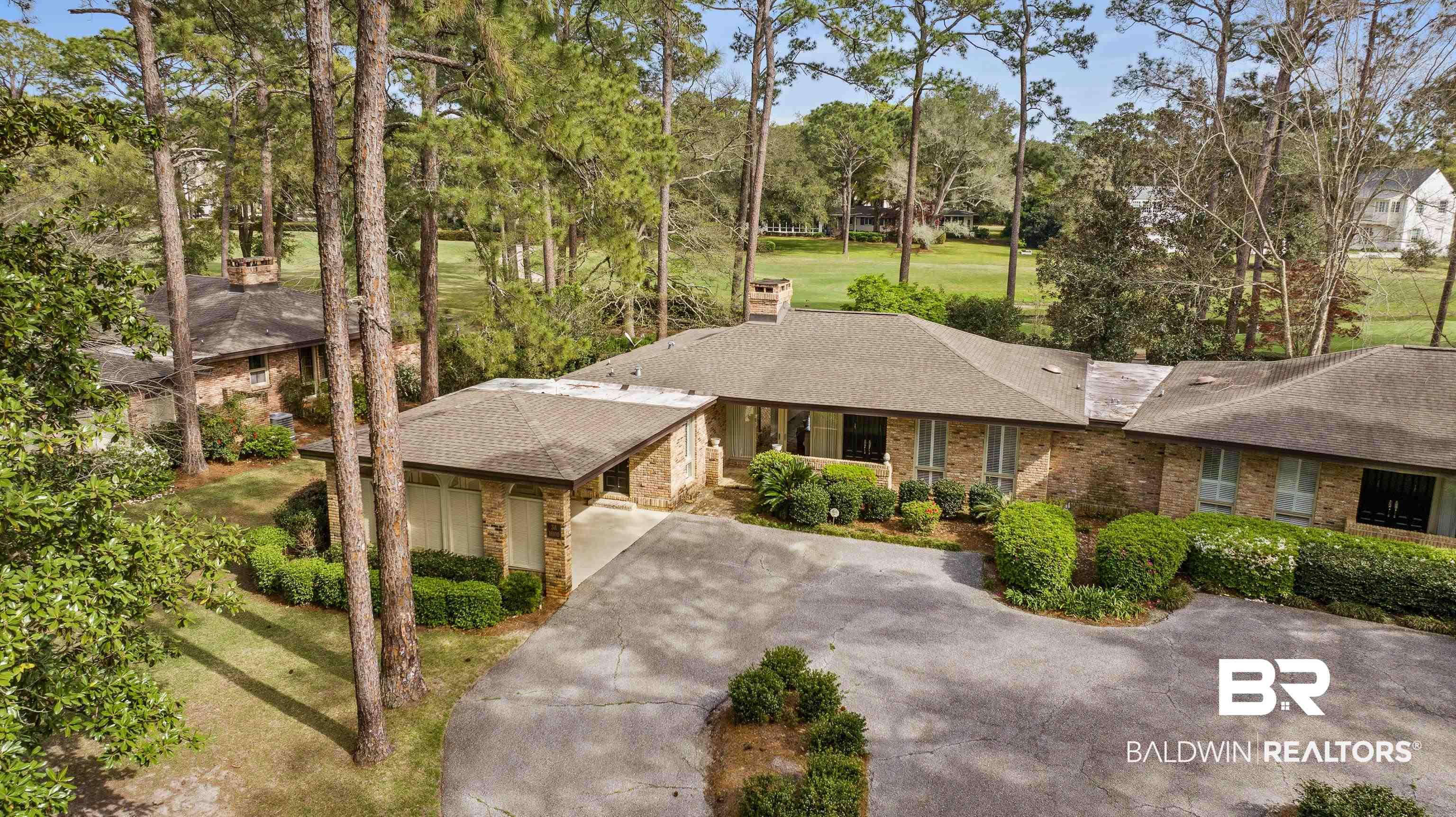 Image 2: View of front of house with driveway, a front yard, roof with shingles, a chimney, and brick siding