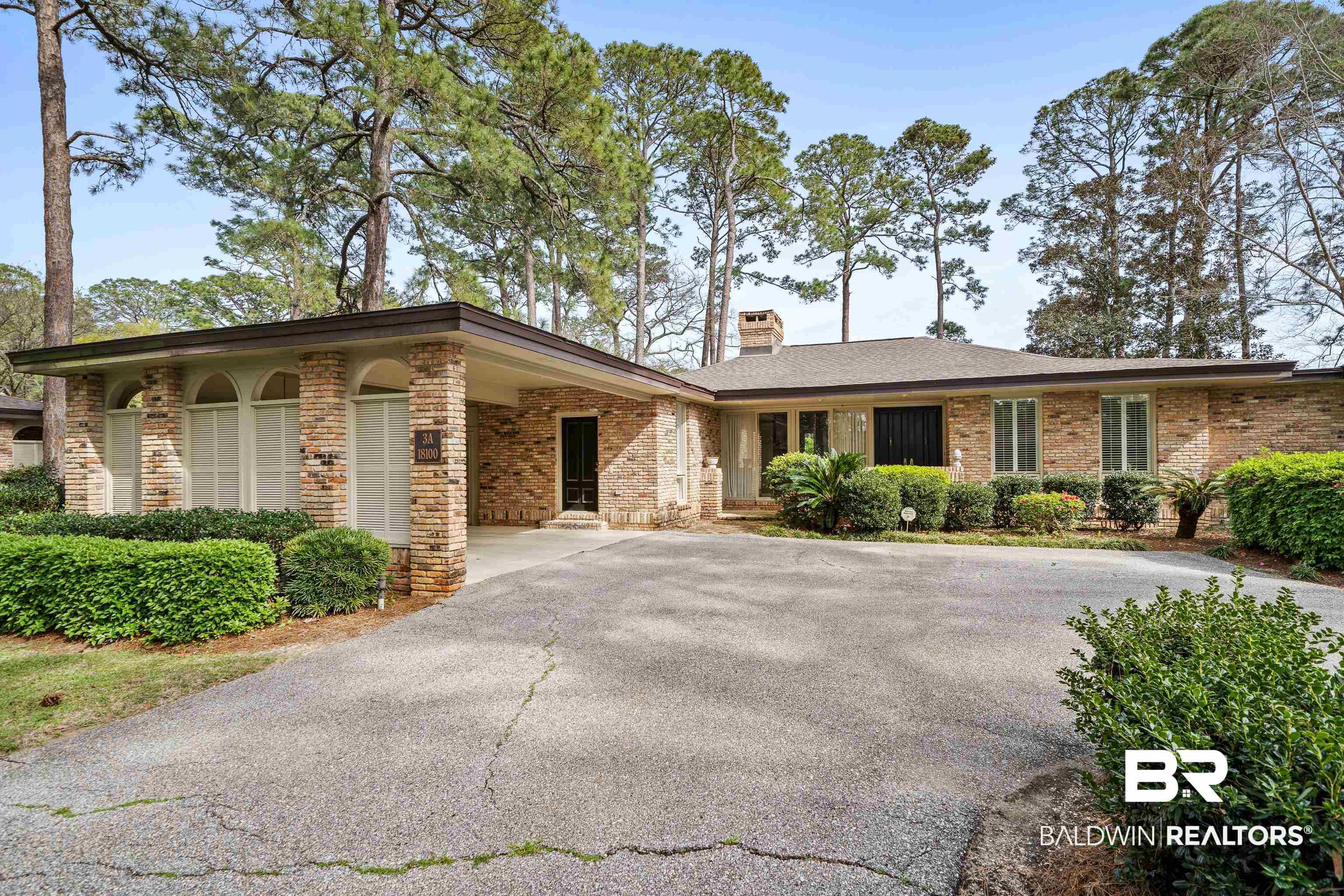 Image 3: Ranch-style house with brick siding, an attached carport, driveway, and a chimney