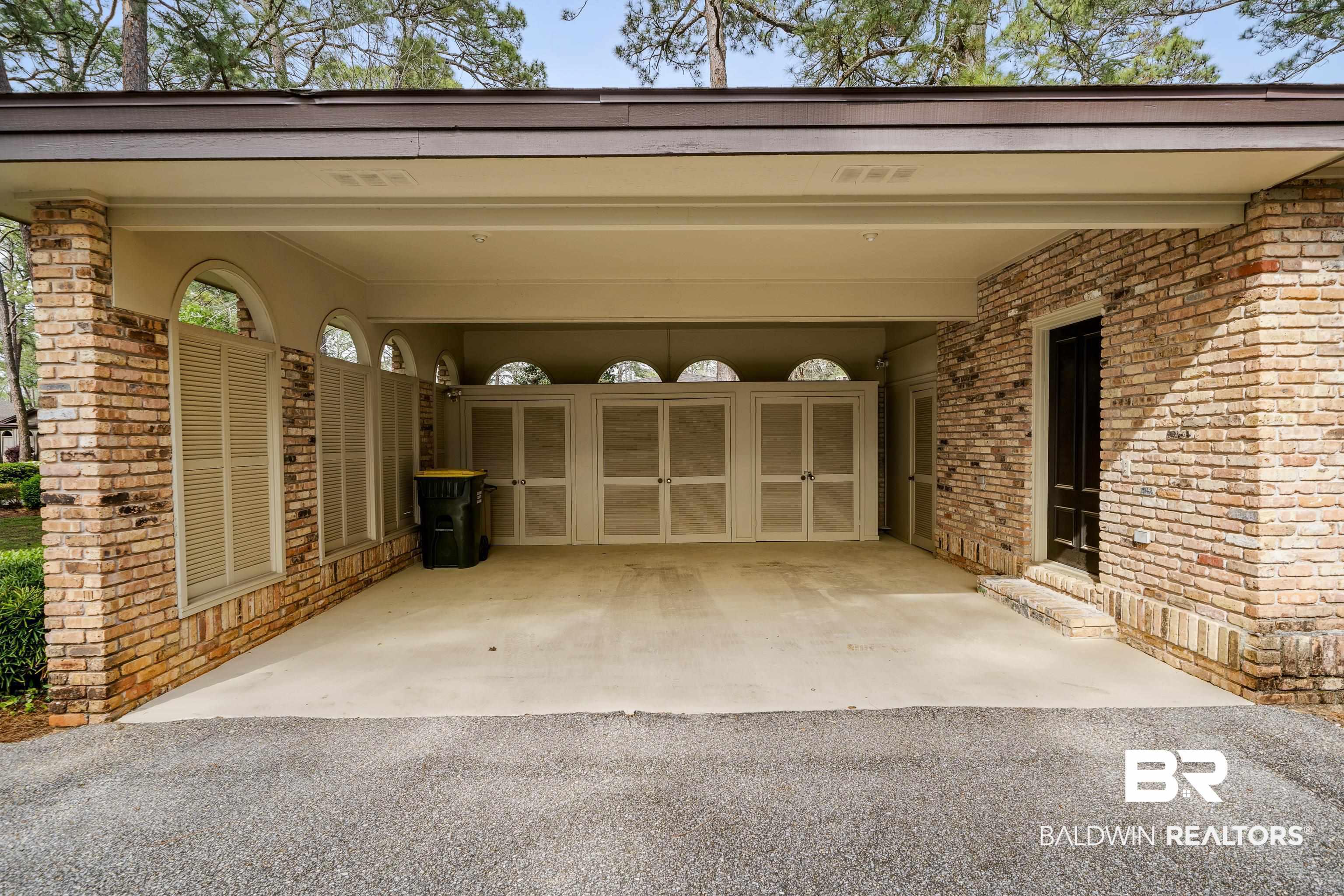 Image 4: Garage with a carport and aphalt driveway