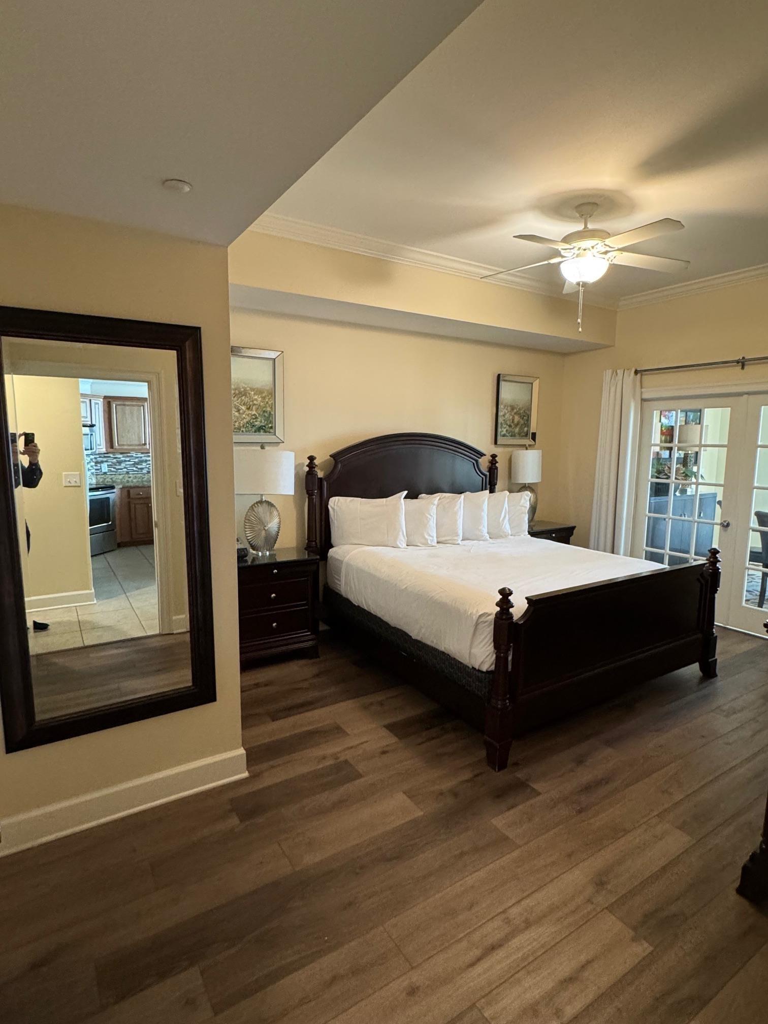 Image 2: Bedroom with ceiling fan, crown molding, dark wood-type flooring, and french doors