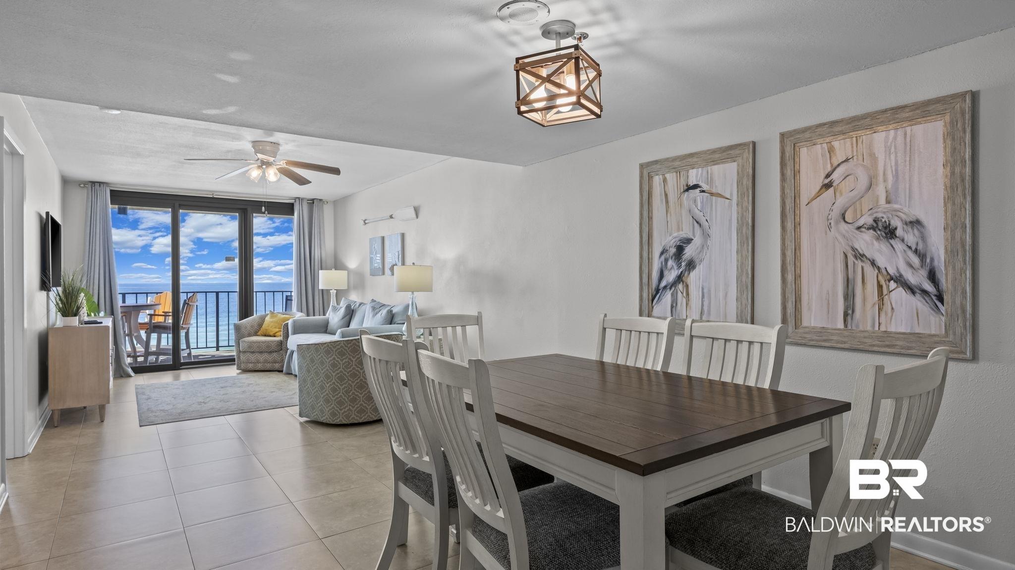 Image 4: Tiled dining room featuring expansive windows and a ceiling fan