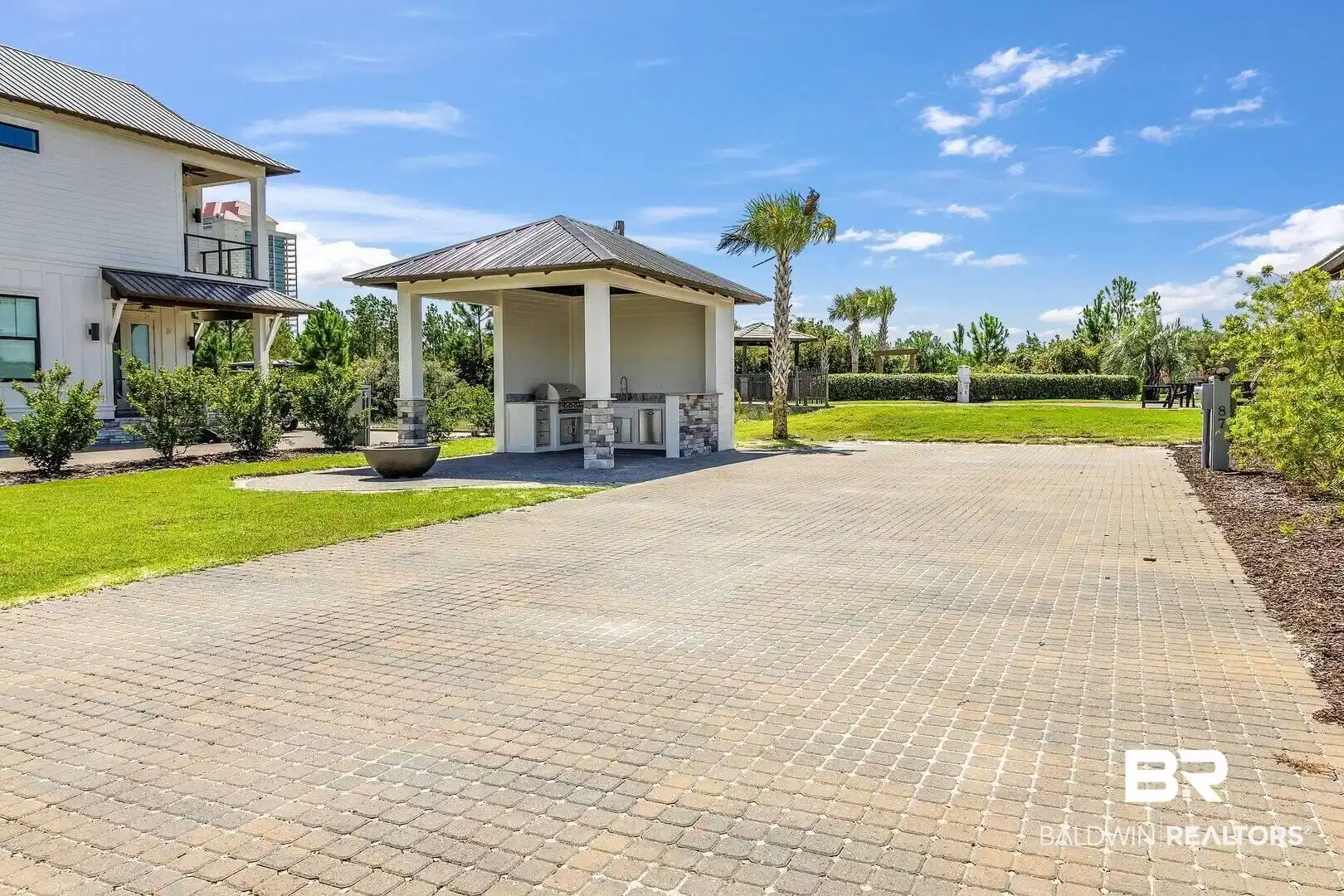 Image 1: Exterior space with a gazebo and decorative driveway