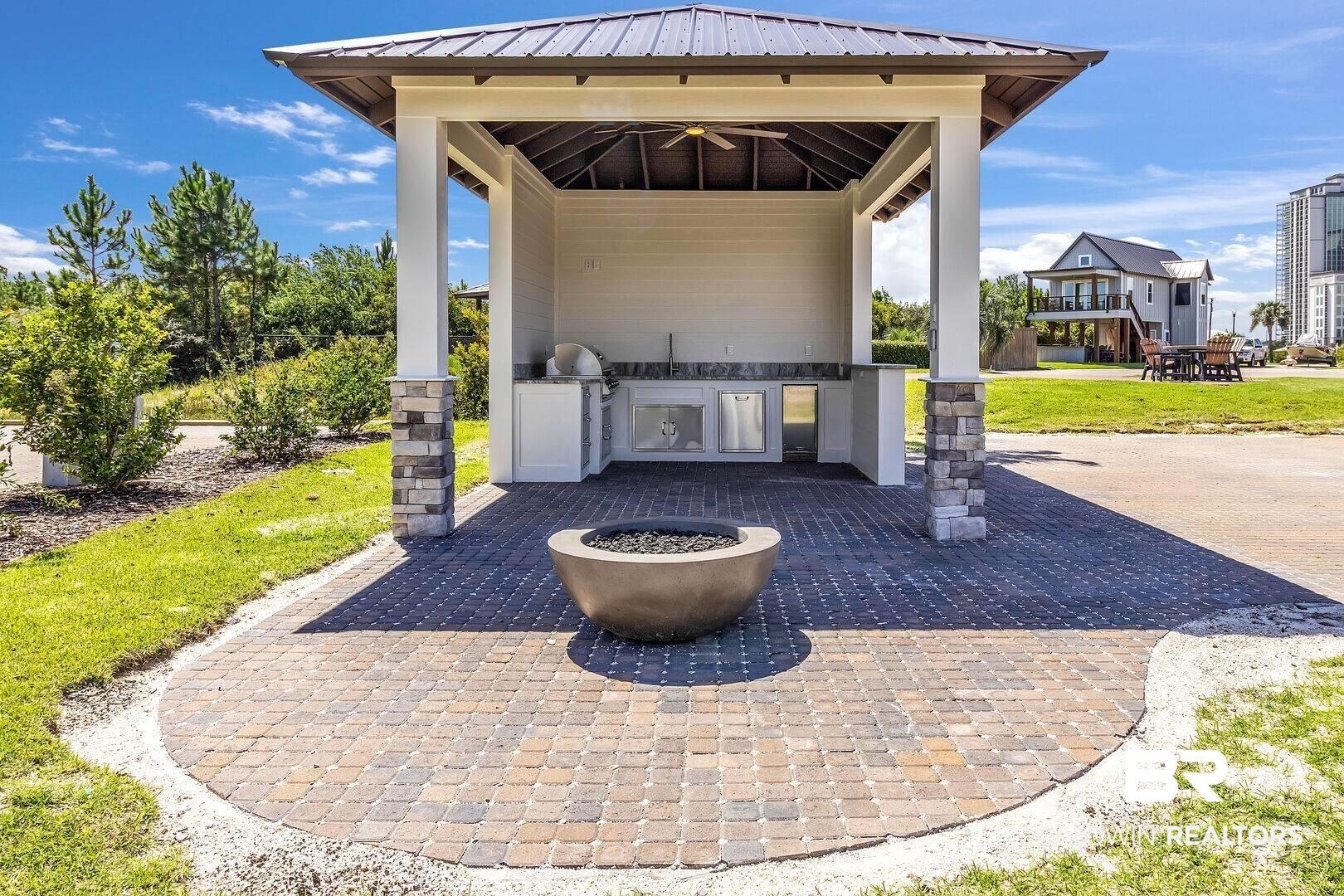 Image 3: View of patio featuring a fire pit, an outdoor kitchen, a ceiling fan, grilling area, and a gazebo