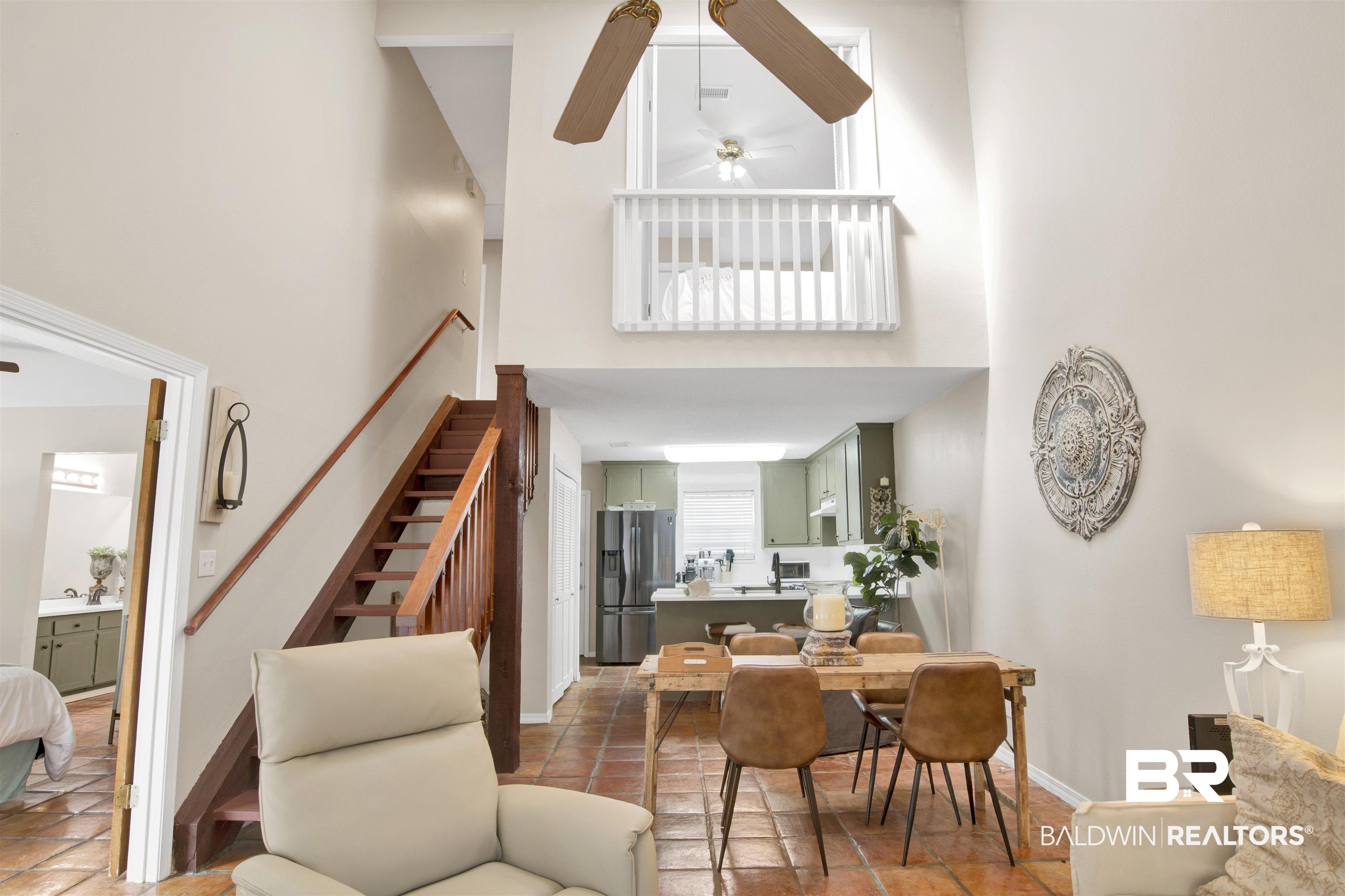 Image 3: Dining area featuring a ceiling fan, a high ceiling, and light tile patterned floors