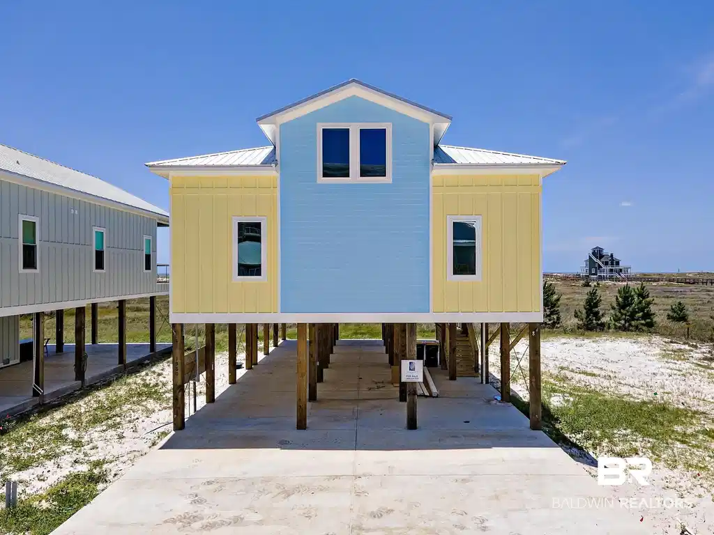 Image 1: Coastal-style architecture featuring cheerful yellow and blue siding