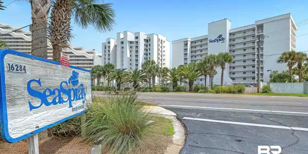 Image 3: The "SeaSpray" sign marks the entrance to a multi-story building featuring multiple balconies and a white exterior