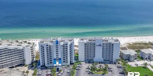 Image 4: Beachfront high-rise building featuring multiple levels of private balconies, direct access to a white sand beach, and expansive ocean waters