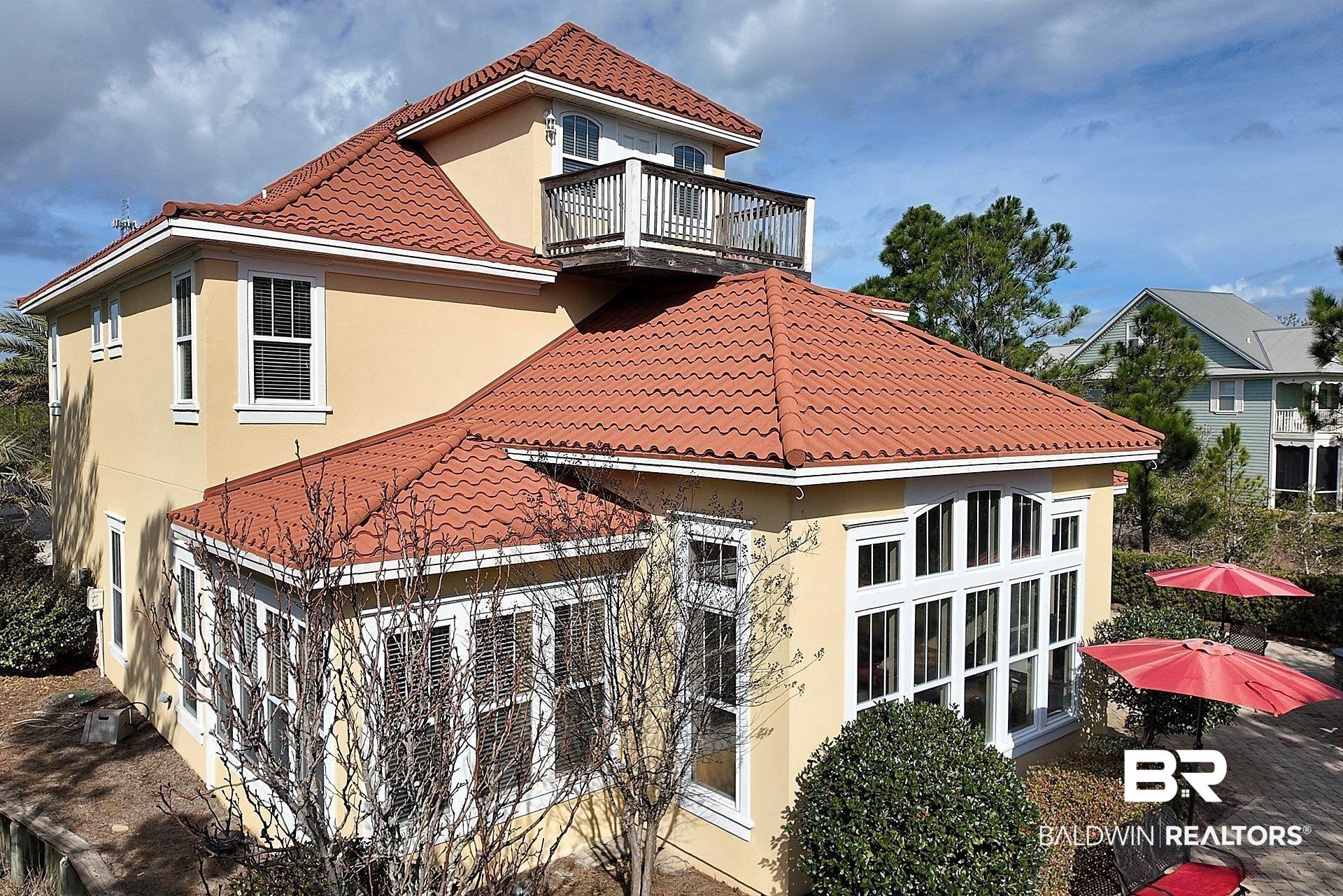 Image 3: Rear view of property featuring stucco siding, a tiled roof, and a balcony