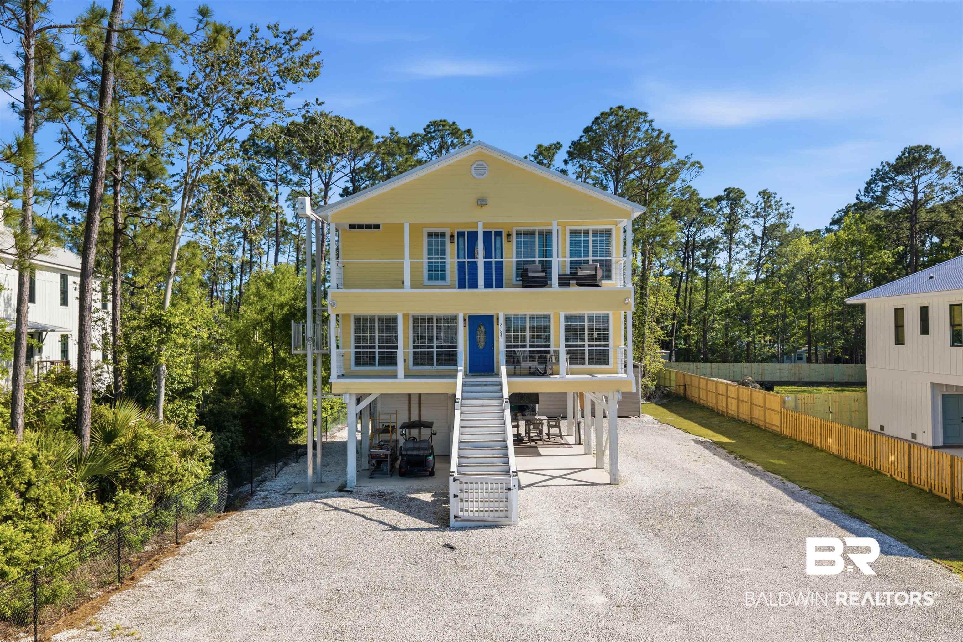 Image 2: View of front of property with driveway, a carport, a patio, and a balcony