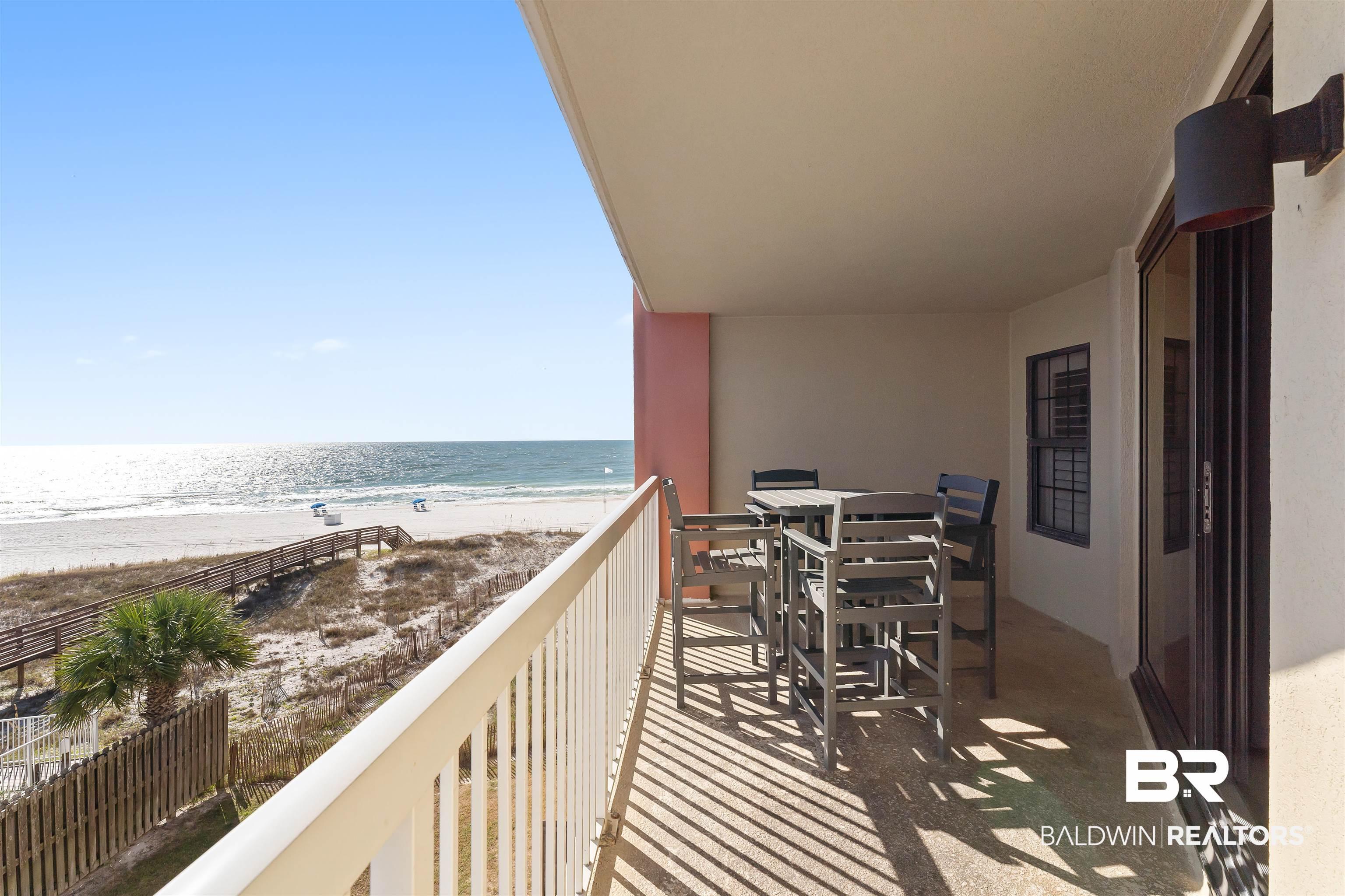 Image 3: Balcony with view of water and beach and outdoor dining area