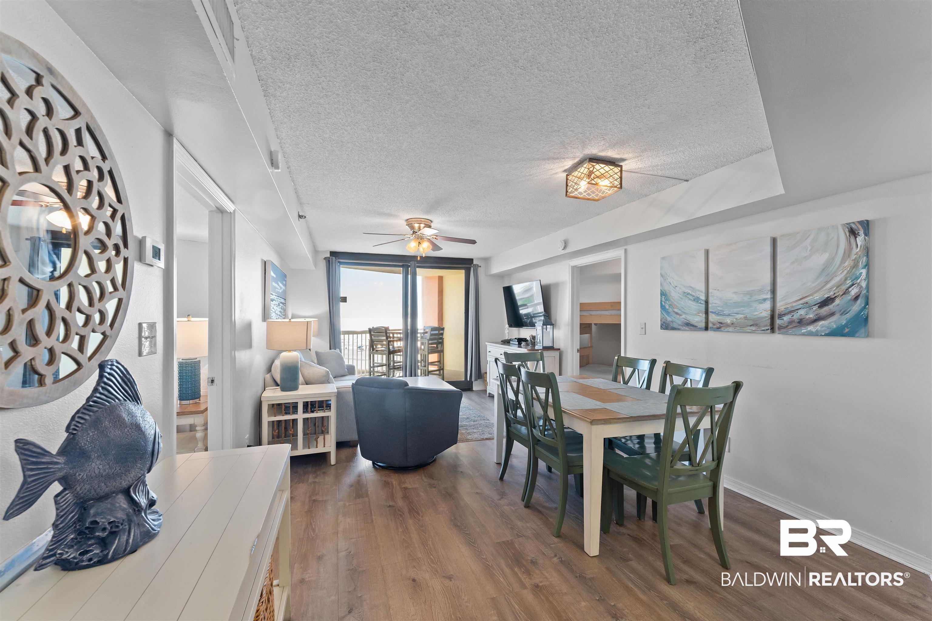 Image 4: Dining area with a textured ceiling, dark wood-type flooring, a ceiling fan, and a wall of windows