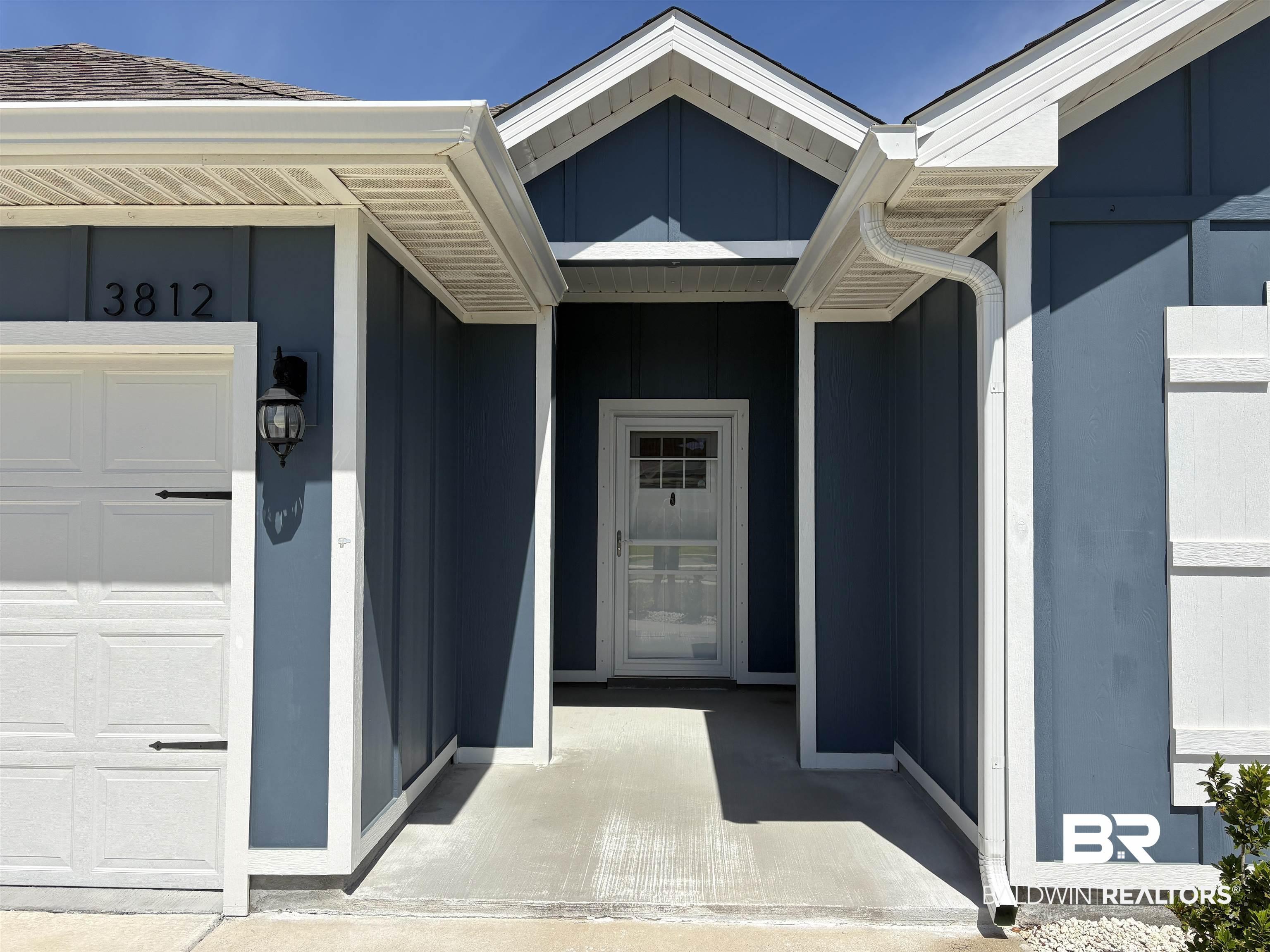 Image 3: Exterior featuring blue siding with white trim, a white garage door, and a covered entry
