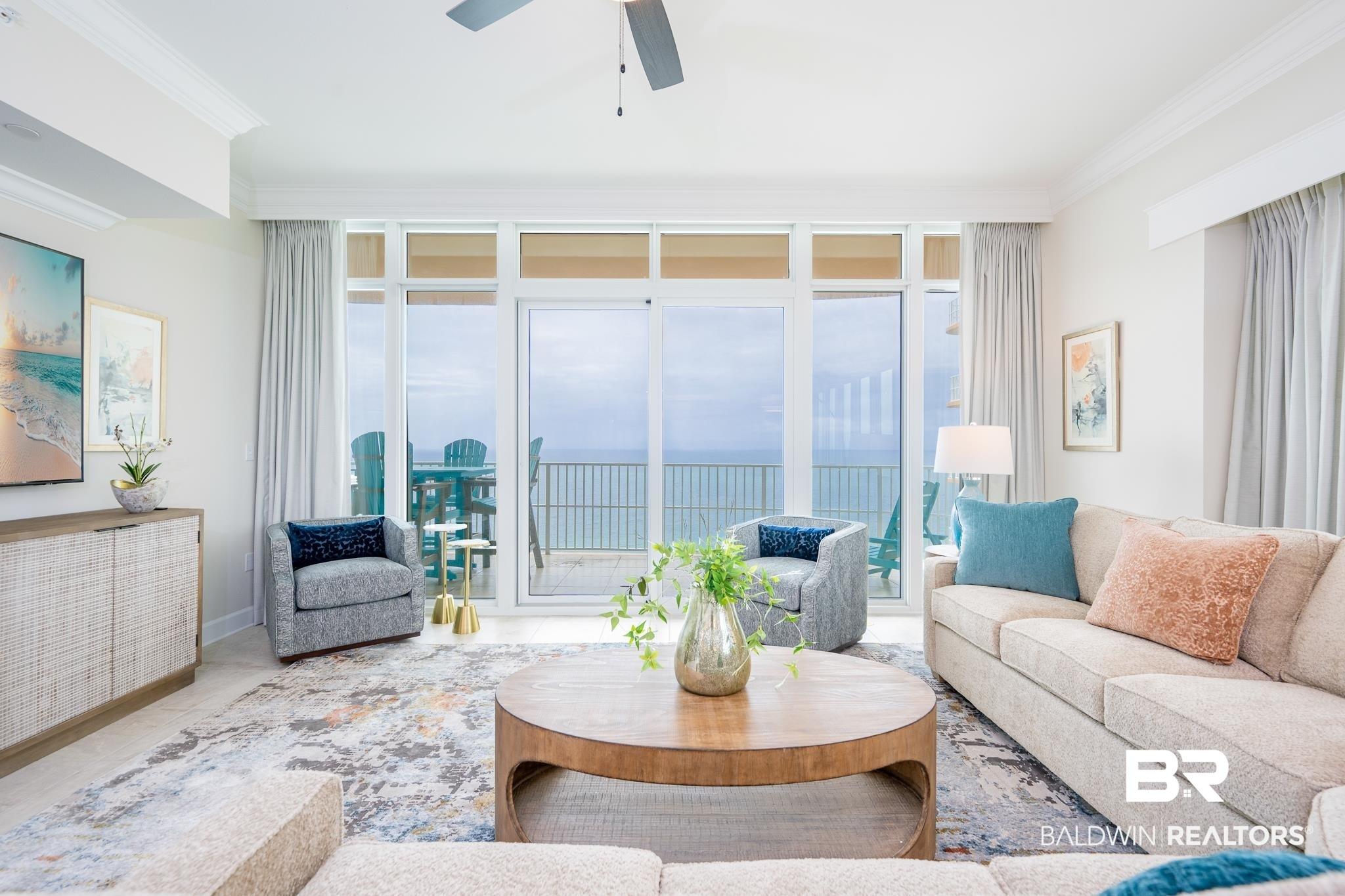 Image 2: Spacious living area featuring large sliding glass doors, crown molding, a ceiling fan, and a built-in credenza