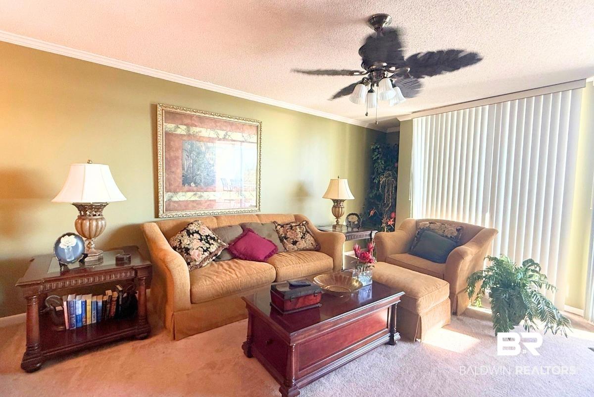 Image 3: Living area featuring ornamental molding, a textured ceiling, carpet, and ceiling fan