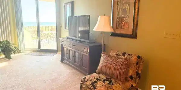 Image 4: Living area featuring light colored carpet, crown molding, and a wall of windows
