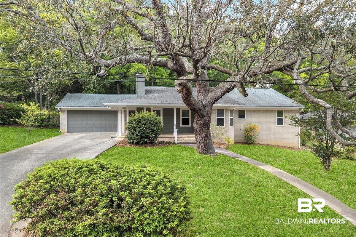 Image 2: Ranch-style home with a chimney, a garage, driveway, a front lawn, and covered porch