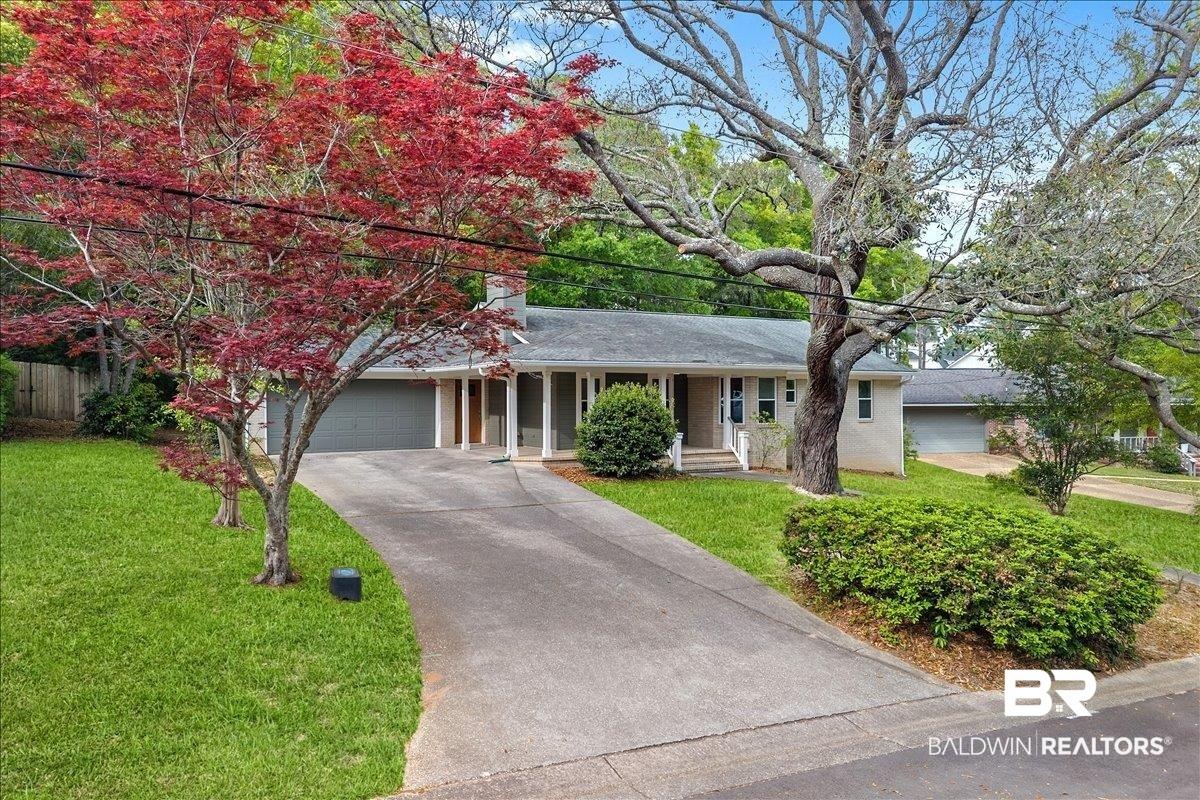 Image 4: Ranch-style house featuring a front lawn, an attached garage, driveway, a porch, and a chimney