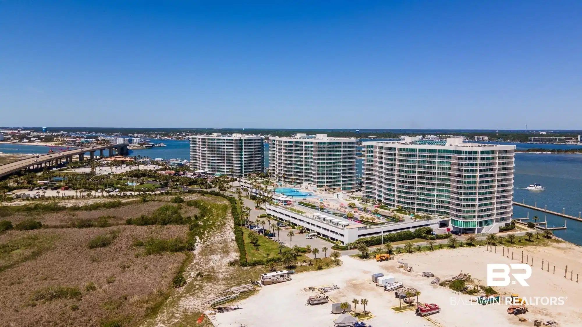 Image 1: Waterfront condominium complex featuring multiple multi-story towers