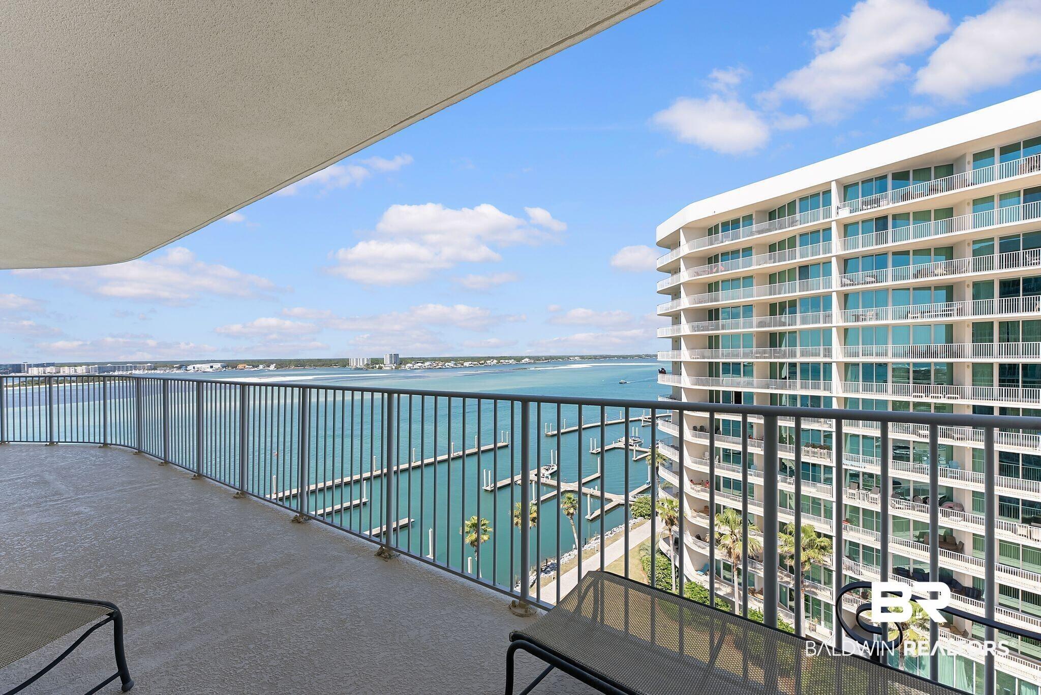 Image 3: Expansive private balcony featuring a textured concrete floor and a durable metal railing