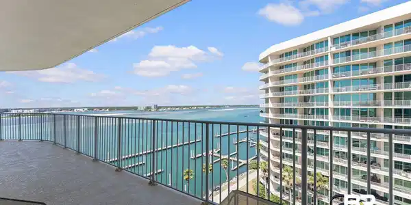 Image 3: Expansive private balcony featuring a textured concrete floor and a durable metal railing