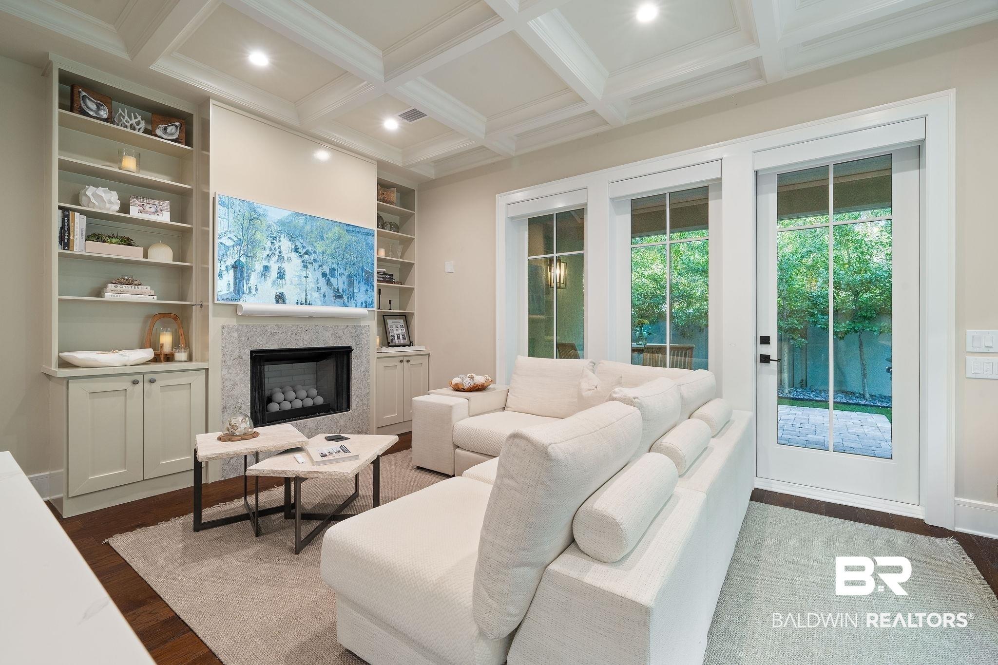 Image 3: Living room with coffered ceiling, crown molding, dark hardwood / wood-style flooring, built in features, and beamed ceiling