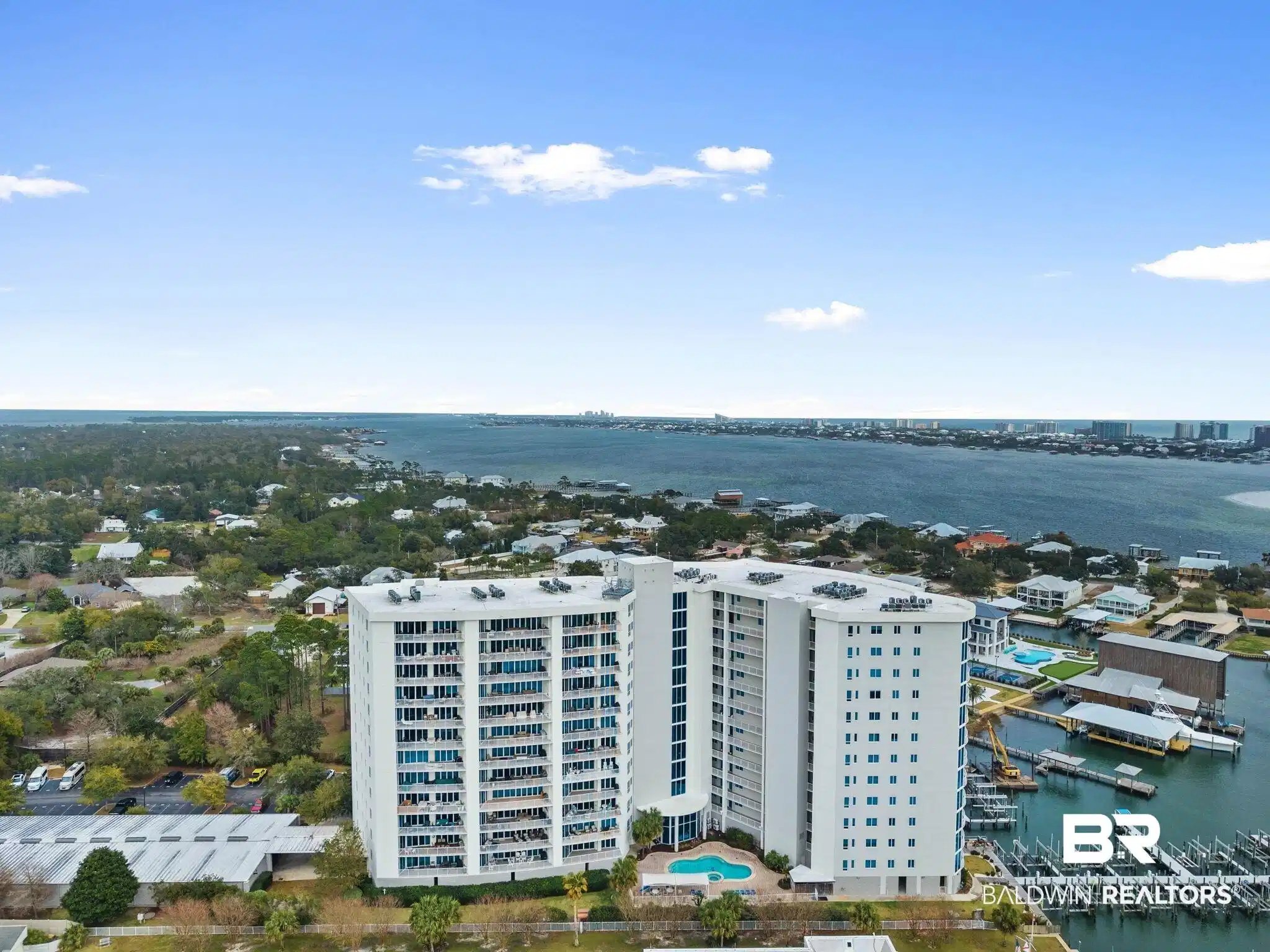 Image 1: Bird's eye view of apartment complex and a nearby body of water