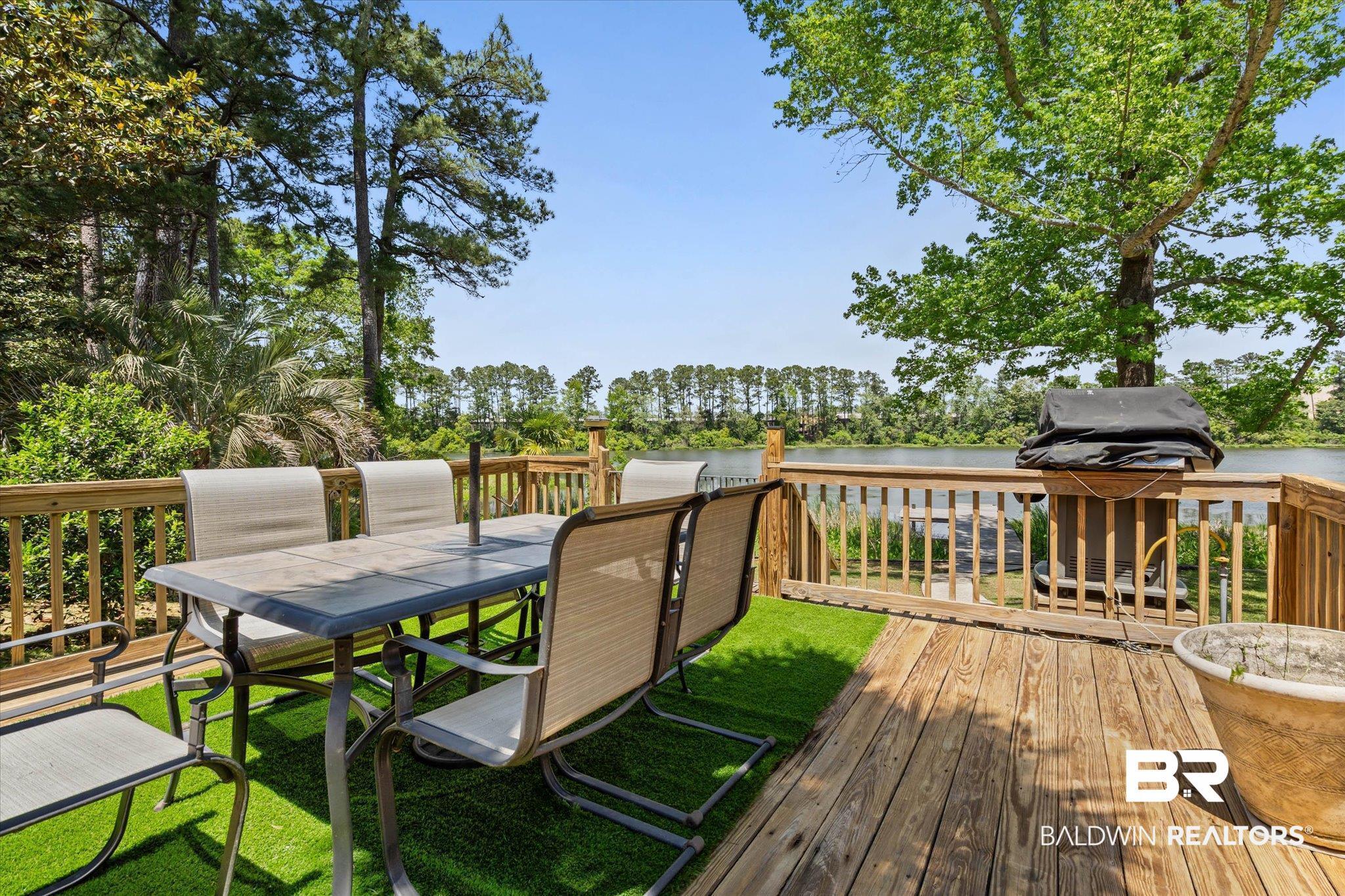 Image 4: Spacious outdoor deck featuring natural wood decking, a built-in railing system, and partial artificial turf surfacing