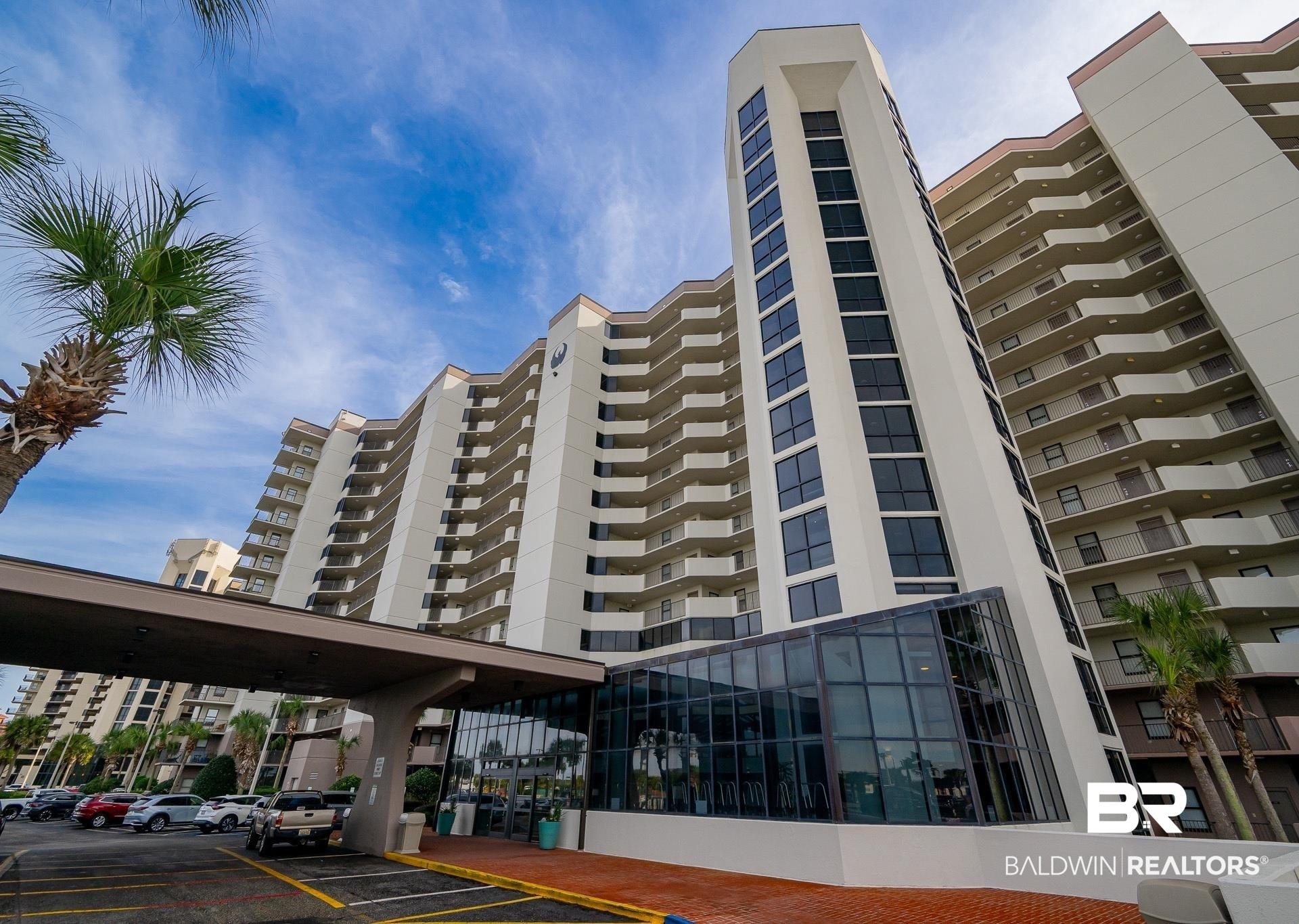 Image 2: Multi-story building featuring numerous private balconies and a prominent glass-enclosed entrance