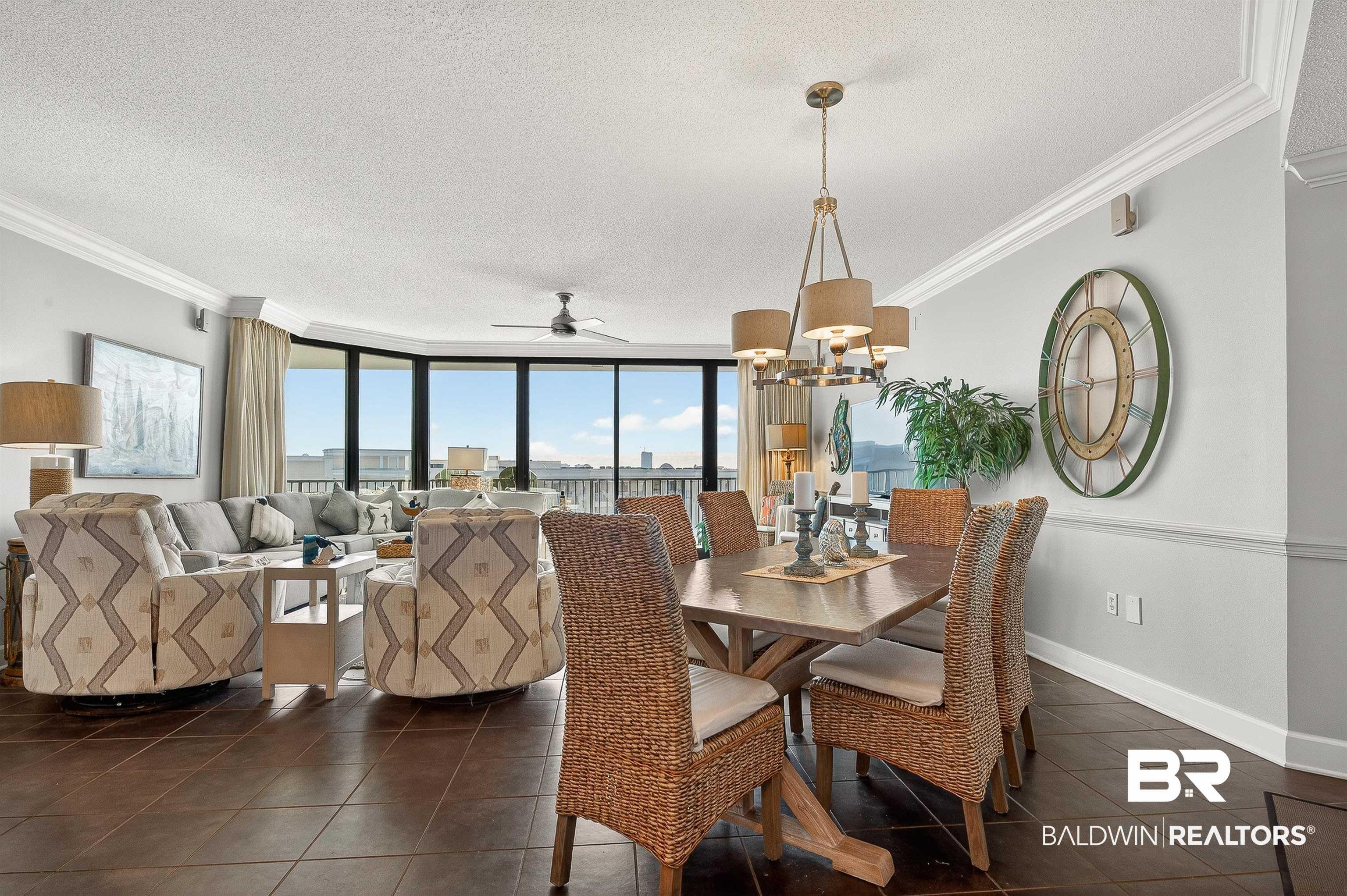 Image 2: Dining area featuring ornamental molding, a textured ceiling, floor to ceiling windows, a chandelier, and dark tile patterned floors
