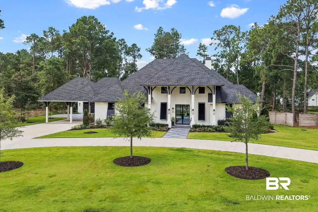 Image 1: Modern white stucco residence with a dark shingle roof and prominent arched entry