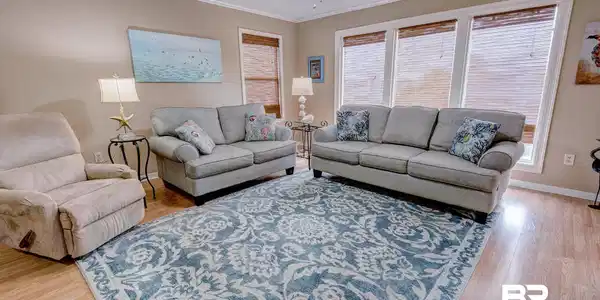 Image 3: Living room with ornamental molding, light wood-style flooring, a textured ceiling, and a ceiling fan