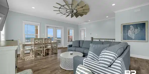 Image 2: Open-concept living area featuring wood-finish flooring, a unique ceiling fan, recessed lighting, and crown molding
