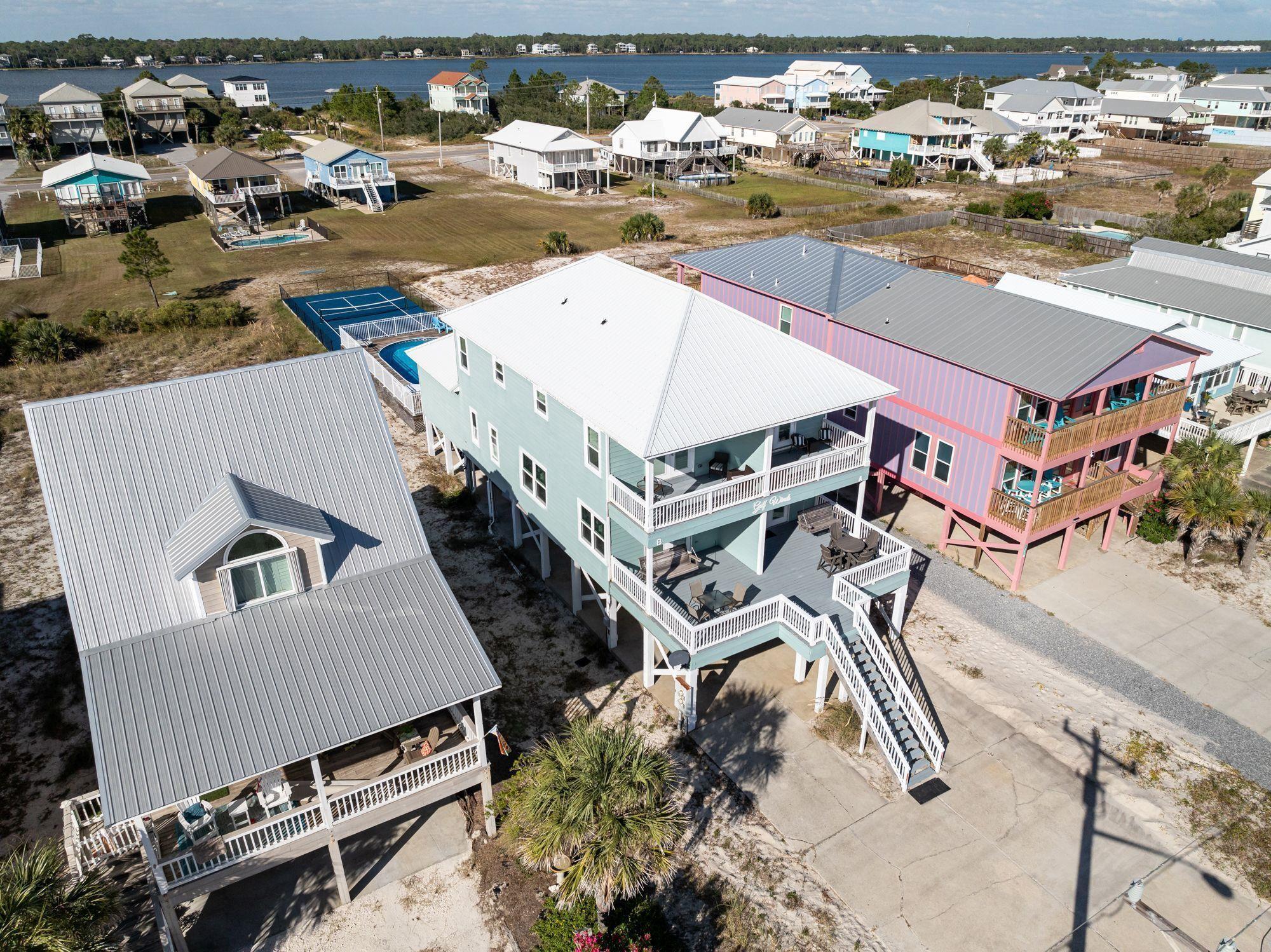 Image 2: Aerial view of residential area featuring a nearby body of water